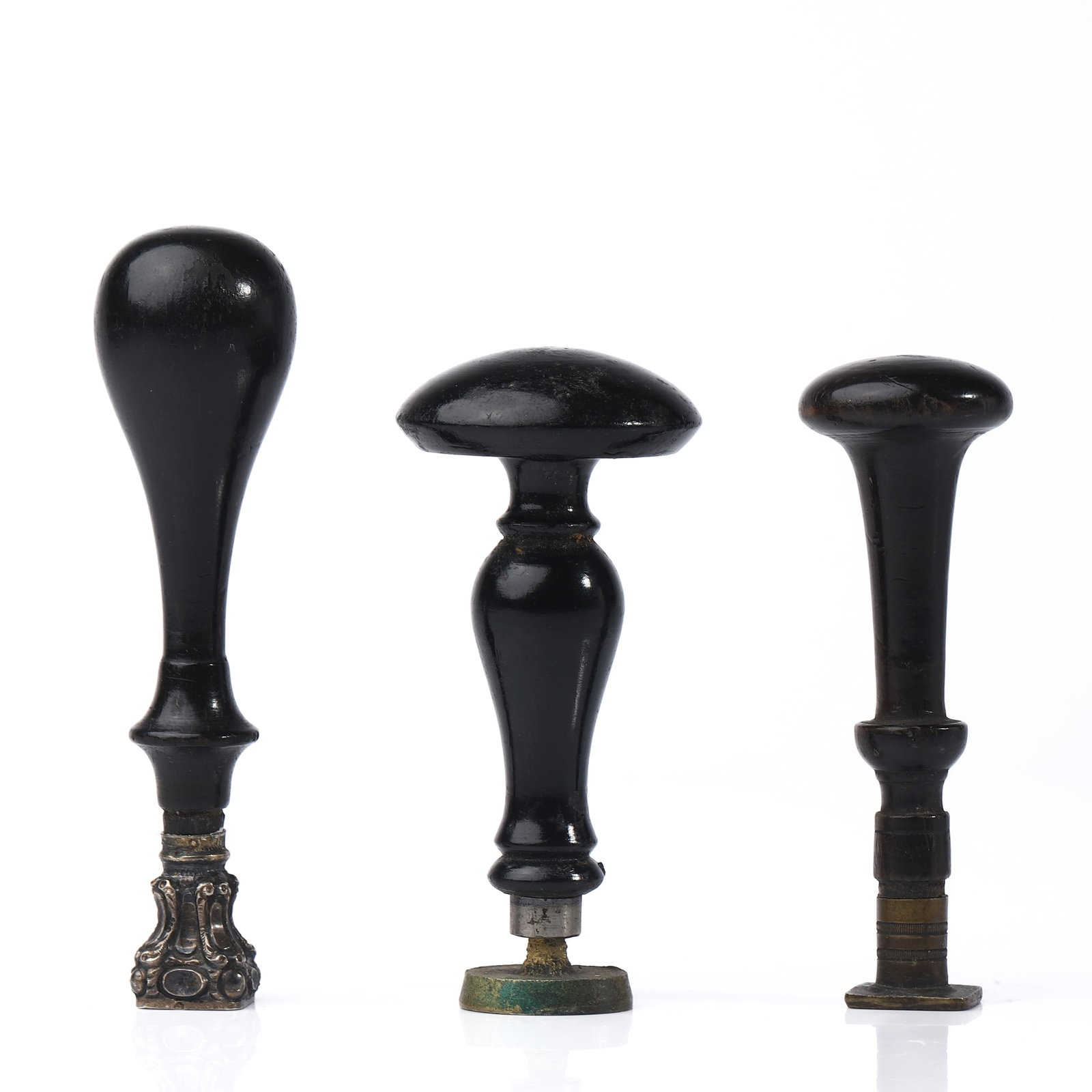 A GROUP OF THREE ANTIQUE WOOD AND BRASS WAX SEAL STAMPS: Dimensions: heights approx. 7.6 cm and 9.1 cm; total weight 40.9 g. Description: A set of three antique wax seal stamps with turned wooden handles and brass seal ends, each featuring different