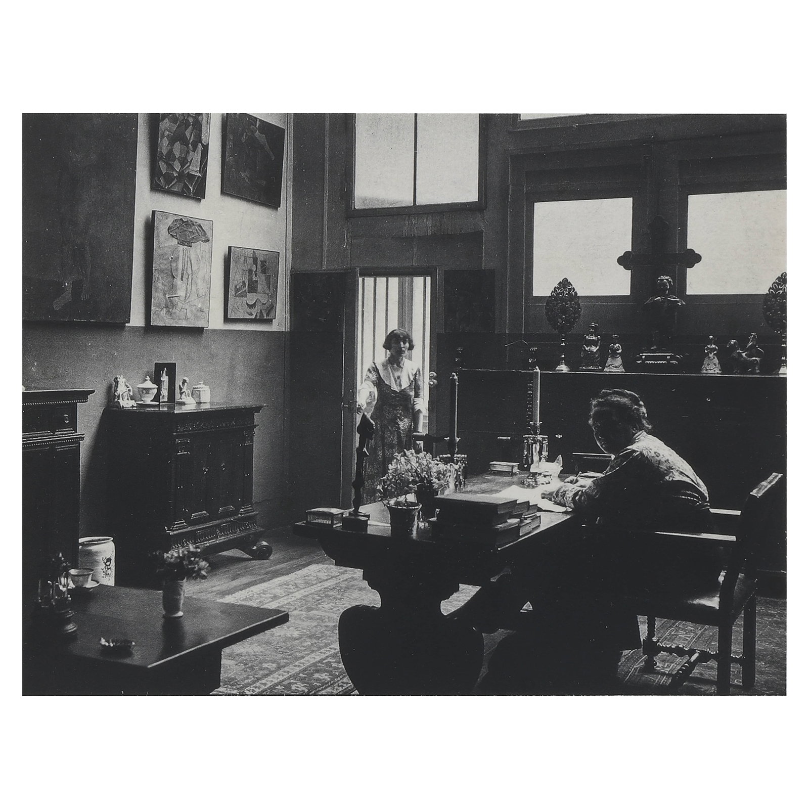 MAN RAY (1890–1976), GERTRUDE STEIN AND ALICE B. TOKLAS IN THEIR RUE DE FLEURUS DRAWING ROOM: Artist Man Ray Title Gertrude Stein and Alice B. Toklas in their rue de Fleurus Drawing Room Medium Silver gelatin print, mounted on board Signature Signed lower right on recto, stamped on verso Dimen