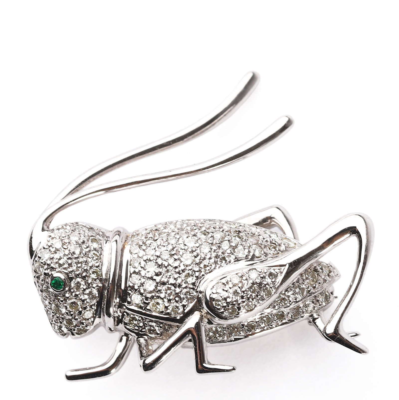 A WHITE GOLD, DIAMOND, AND EMERALD BROOCH OF A GRASSHOPPER: Dimensions: Width: 1 3/16 in. (30 mm); Height: 1 3/16 in. (30 mm); Weight: 10 g Modeled as a stylized grasshopper in motion, this brooch is crafted in 18k white gold, as marked "750" on the reverse.