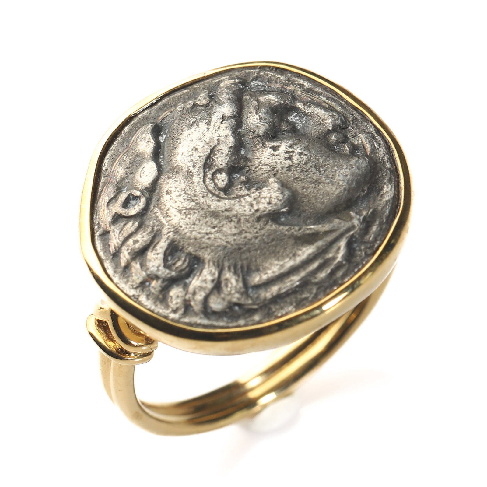 ANCIENT GREEK HERCULES LION SKIN HELMET COIN RING IN 18K GOLD MOUNT: Dimensions Hong Kong Size 14 Weight 7.86 g Description An evocative classical revival ring inspired by Ancient Greek coinage, finely mounted in 18K gold and set with a silver coin depicting the head