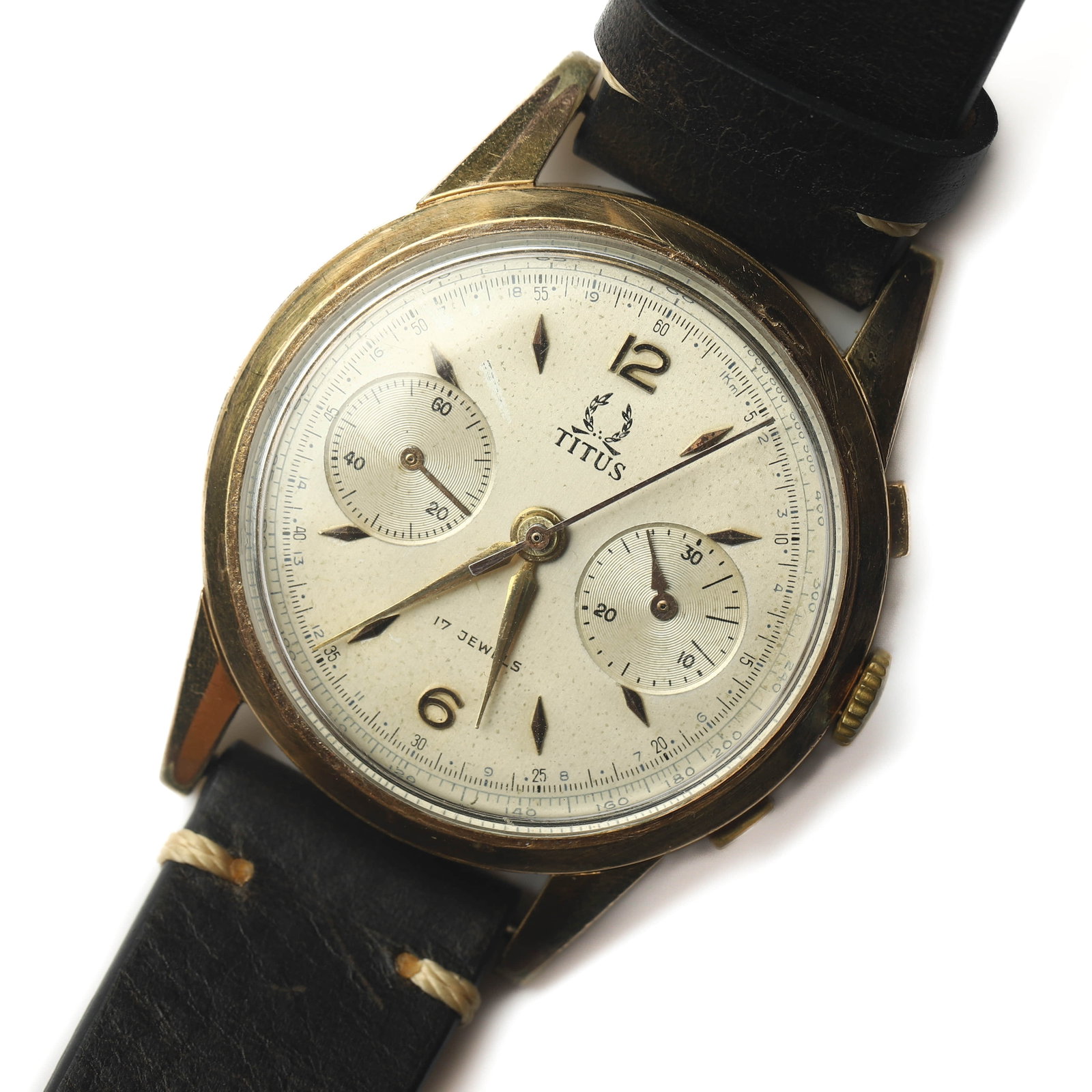 TITUS 17 JEWELS TWO-REGISTER CHRONOGRAPH WRISTWATCH: Dimensions Overall Length 9 7/16 in. (24 cm) Case Diameter 1 1/2 in. (3.88 cm) Weight 48.2 g Description A vintage Titus 17 jewels manual-wind chronograph wristwatch featuring a gold-tone round case, 