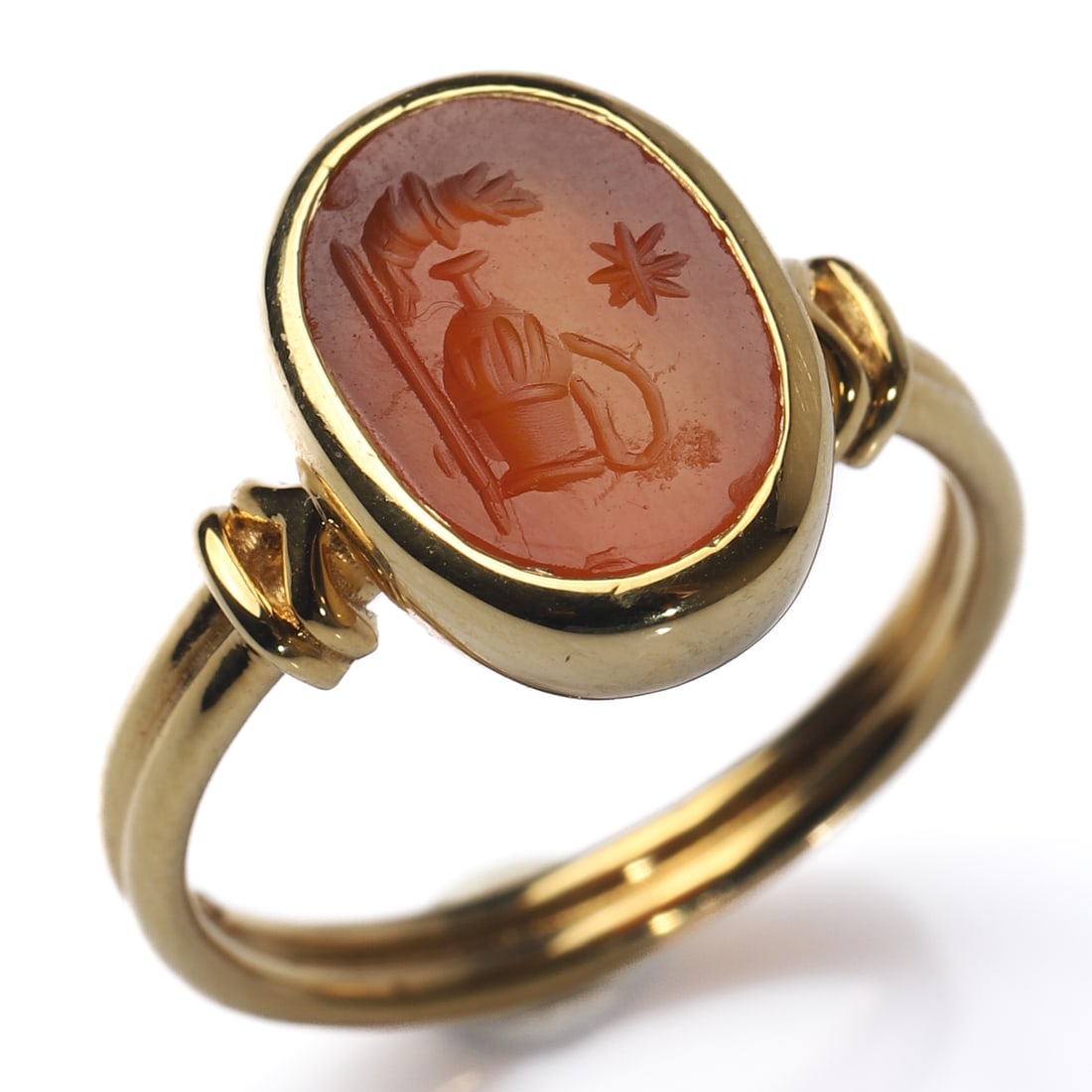AN ANCIENT ROMAN AGATE INTAGLIO RING, 18K GOLD MOUNT: Dimensions Ring Size: HK 13; Weight: 4.35 g Description An 18K gold ring set with an ancient Roman agate intaglio. The engraved seal depicts a composition of a military standard, an amphora, and