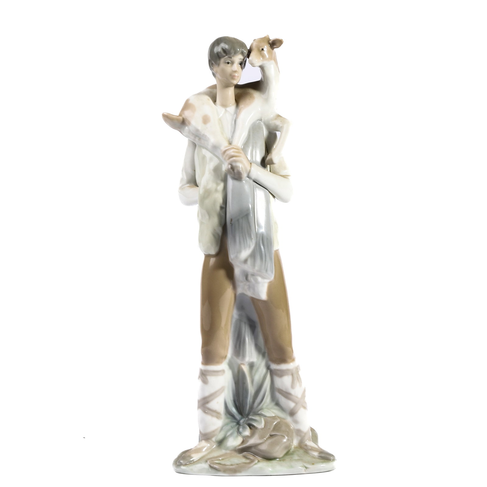 A LLADRÓ PORCELAIN FIGURE OF A SHEPHERD WITH LAMB: Height Height: 10 13/16 in (27.5 cm) Modelled as a young shepherd standing with a lamb draped across his shoulders, dressed in rustic attire and raised on a naturalistic base. Glazed in soft pastel hu