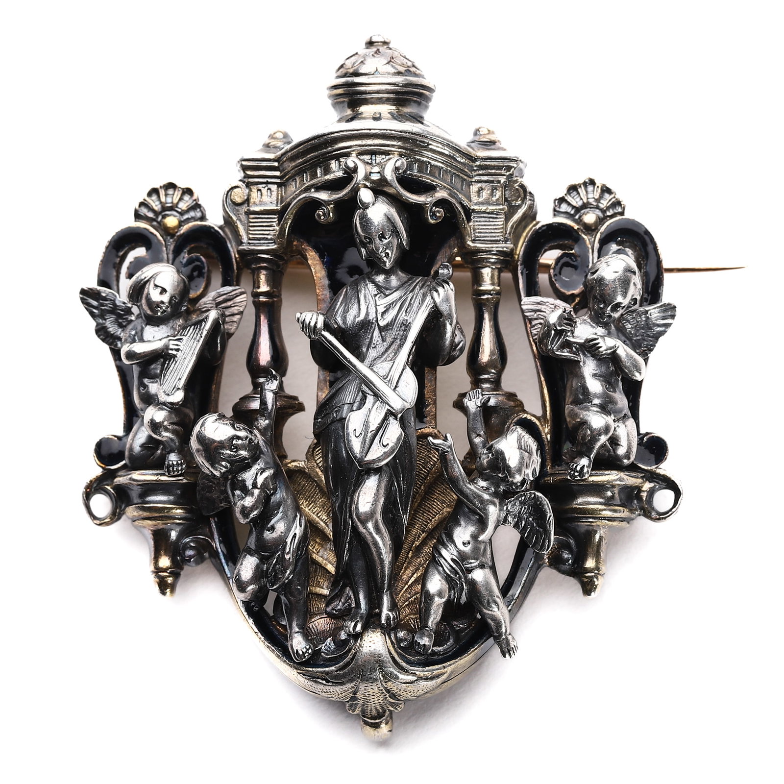 A CONTINENTAL SILVER AND ENAMEL FIGURAL BROOCH, TROUVAIN & MAURICE: Dimensions Length: 1 11/16 in (4.3 cm) Width: 2 in (5 cm)Weight: approx. 11/16 oz (20 g). The brooch finely modeled as a central female figure playing a bowed string instrument beneath an architectura