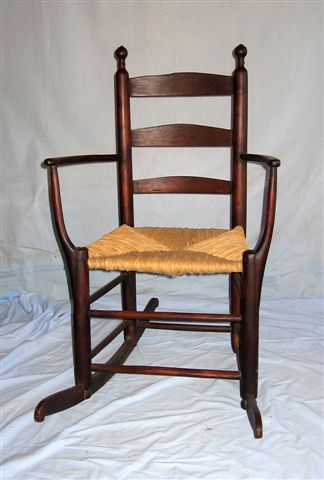Early American Armed Rocking Chair, cherry: Early Armed Rocking chair, American, late 18th-early 19th cent, cherry, ladder-back, slightly scrolled rocker ends, square iron nails supporting the wide & thin tapered arms, newer rush seat . 38 ½��