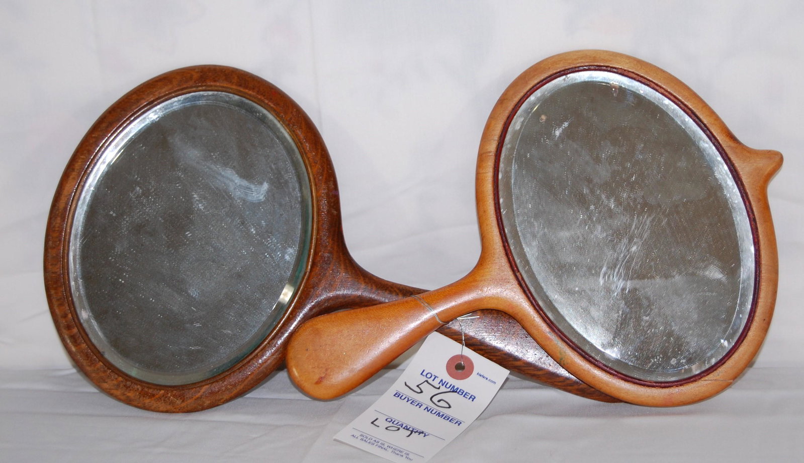 Vintage Oval Hand Mirrors in Maple & Tiger Oak: Two Vintage c. 1900 Oval Bevel Glass Hand Mirrors. One in maple, 7 1/2", with old repair to frame. One in tiger oak 7 1/2".