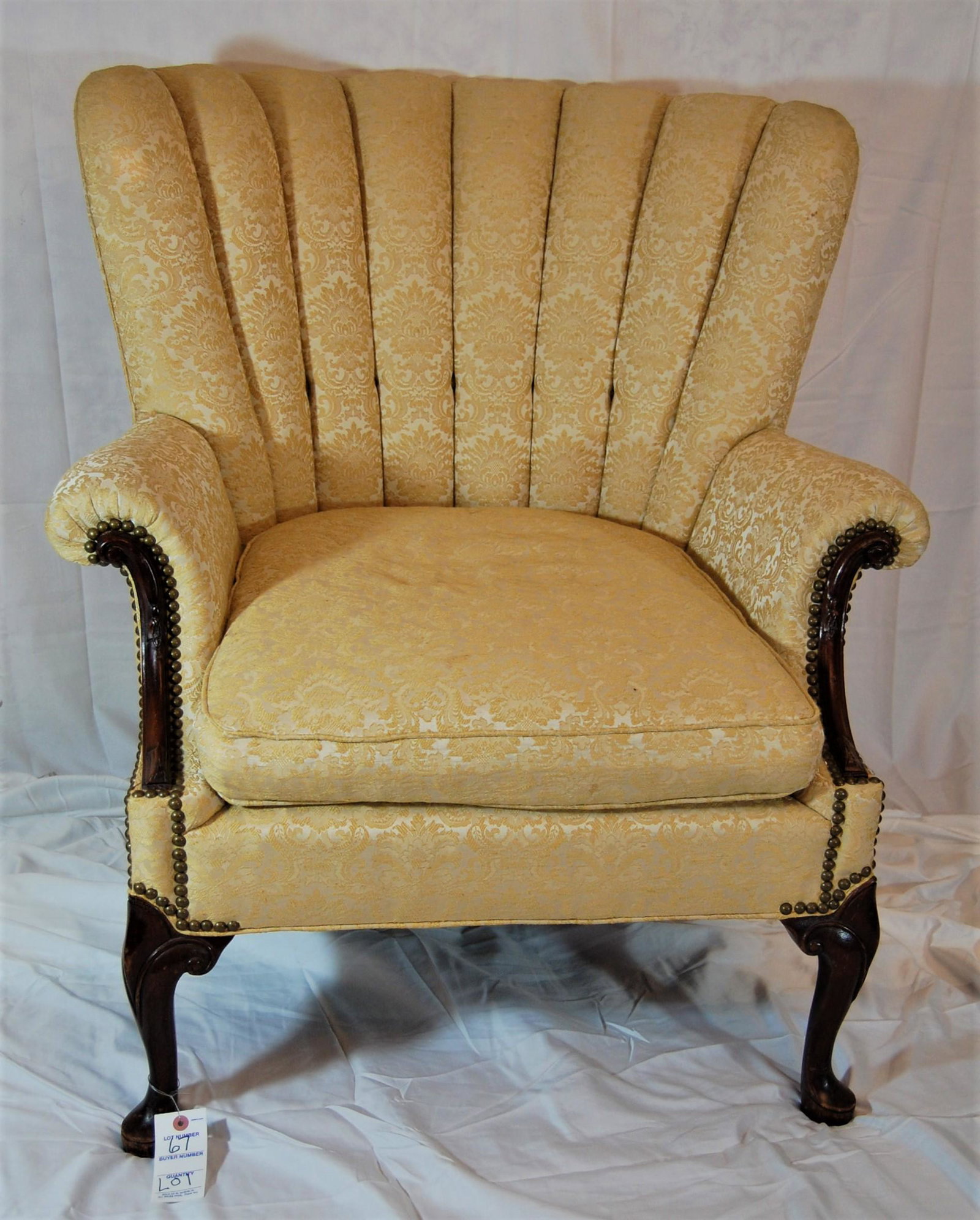 Early 20th Cent Wing Chair & Needlepoint Stool: Early 20th Century Fan Back Wing Chair and Needlepoint Footstool. Chair is in gold brocade fabric. Needlepoint footstool is fringed. Chair is 36"h x 33"w. Footstool is 14"d.