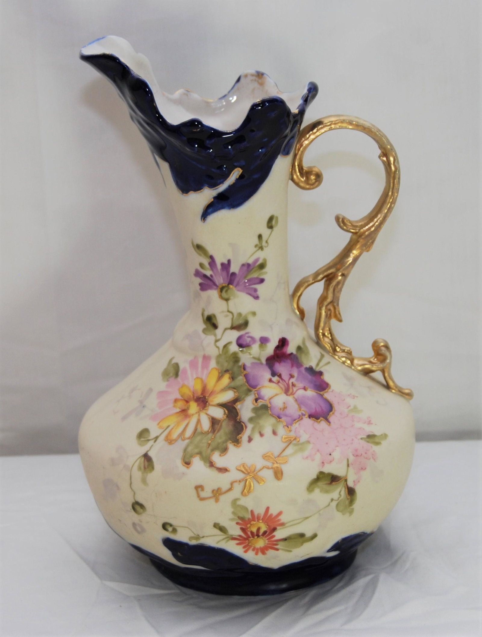 Art Nouveau Austrian Porcelain Ewer-19th cent: Art Nouveau Austrian Ewer. A late 19th century porcelain Art Nouveau ewer with graceful lines and shape, with hand-painted daisies and lilies and a gold gilt vine-shaped applied handle. Marked by "G &