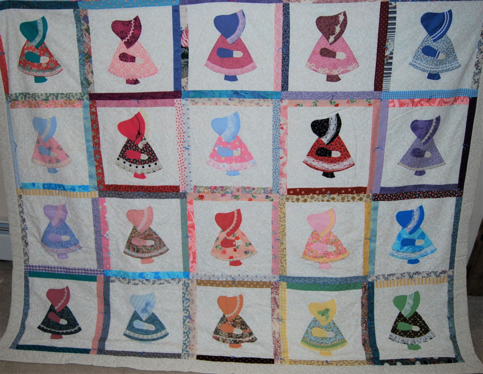 Hand-Made Sunbonnet Sue Quilt: A 1990s vintage meticulously hand-made quilt depicting Sunbonnet Sue in 20 different squares in 20 different outfits. 86" x 74". A great example of this classic quilt. The quilt was made by Mary Madde