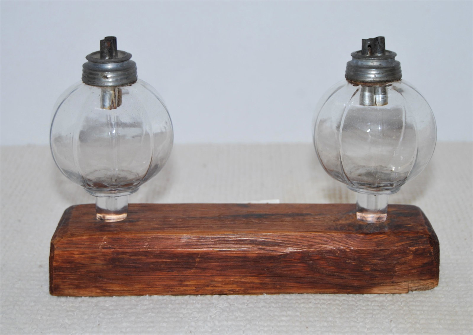 Antique Whale Oil Peg Lamps-blown glass-1800s: Antique Whale Oil Peg Lamps, 1800's. A pair of clear glass peg lamps with burners. The lamps are 11-sided and are hand-blown-into-a-peg-mold, pontil marks are visible on the pegs and glass bubbles are