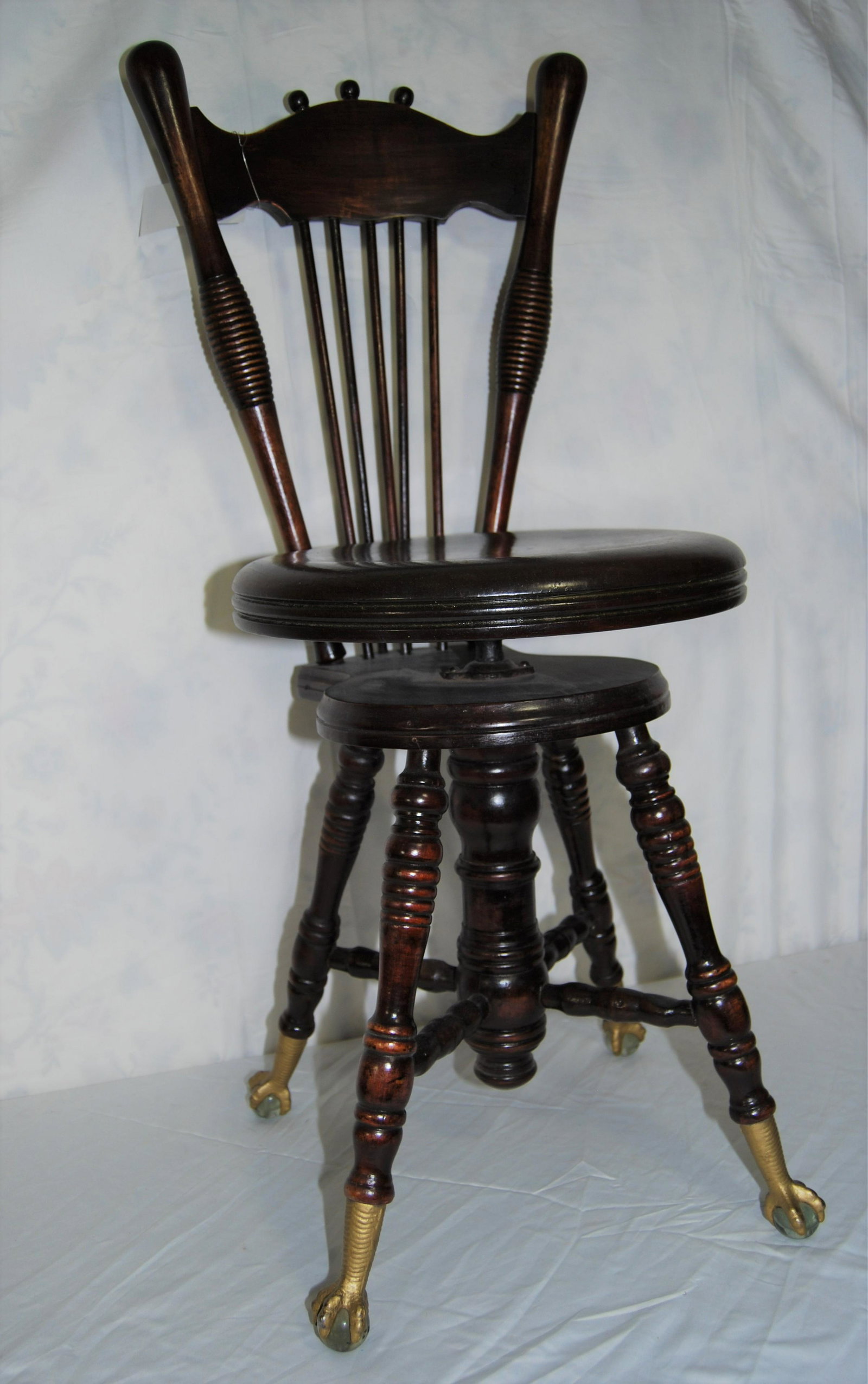 Victorian piano stool, claw glass ball feet: Victorian piano stool, 19th century mahogany fan-and-braced backed stool with swivel seat, turned legs and brass-painted iron eagle claw feet on glass balls. Seat height 18½” when spun down
