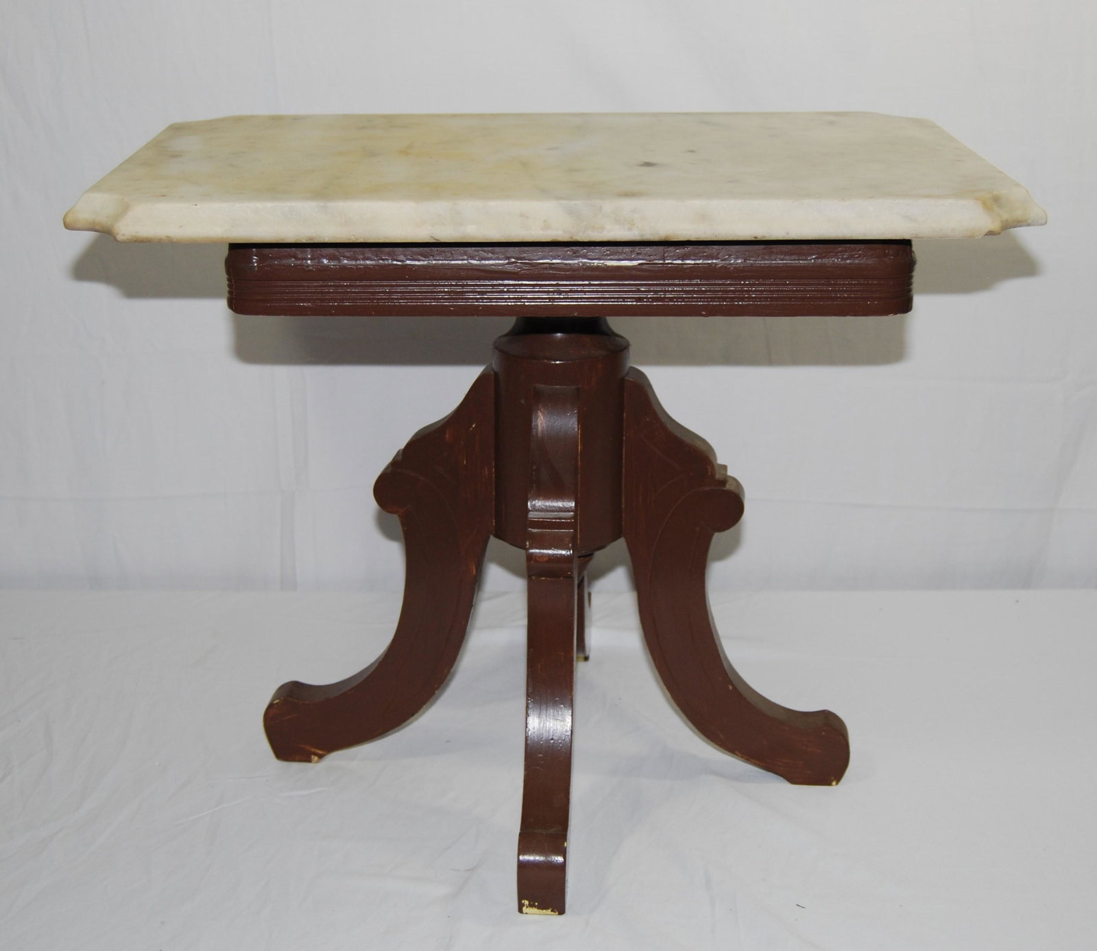 Victorian Marble Top Table-top spins up & down: Victorian Marble Top Table. The table has 4 curved legs, brown painted over what appears to be mahogany. This is a table converted from a piano stool -so the top spins up & down. Paint is in fair shap