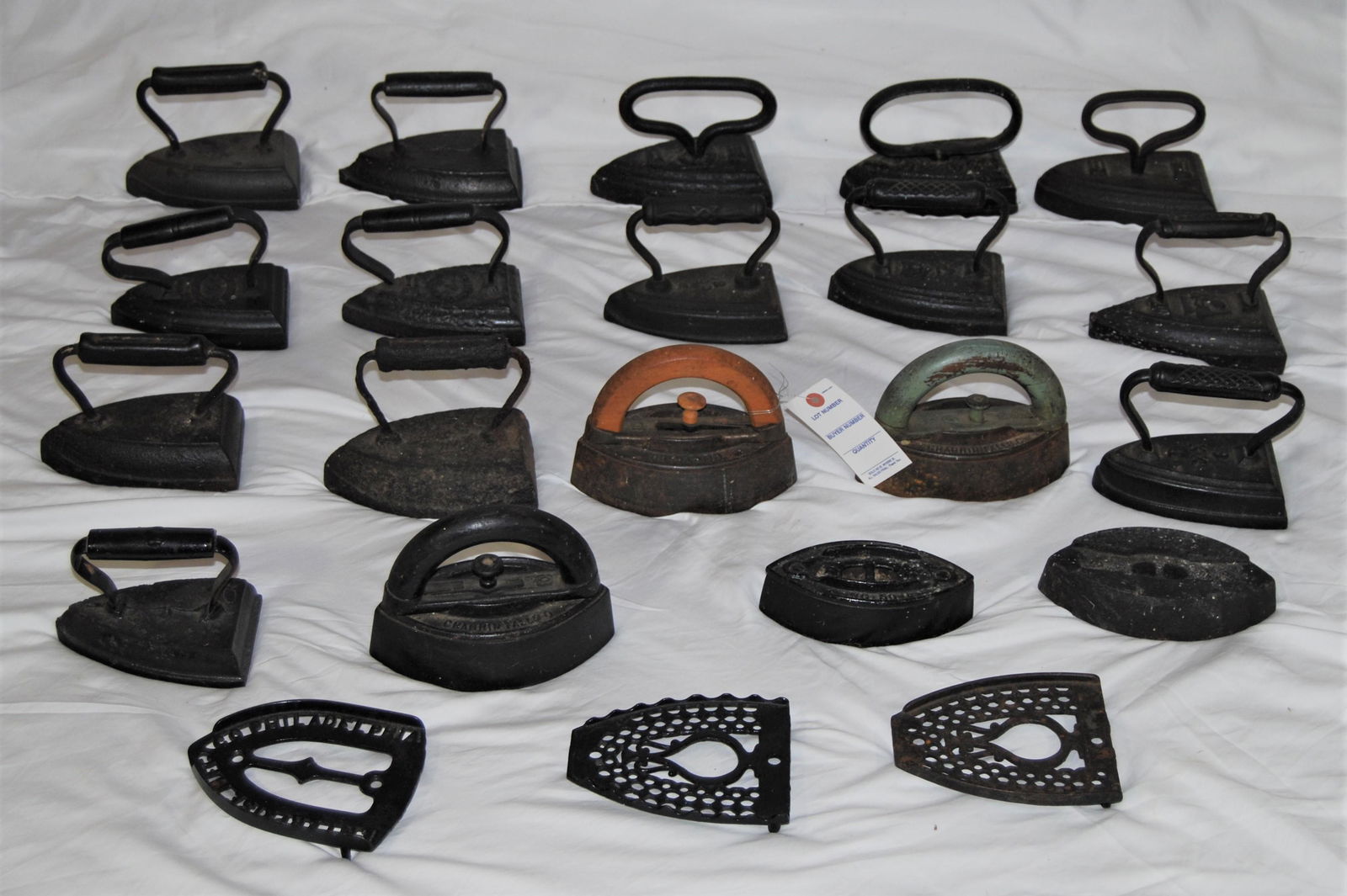 Antique Sad or Flat Irons - lot of 19 irons: Antique Sad or Flat Irons. Lot of 19 sad irons. One is by “Chagrin Falls.O”. The others are not labeled. Also included are 3 iron rests or trivets. 2 sad irons are without handles.