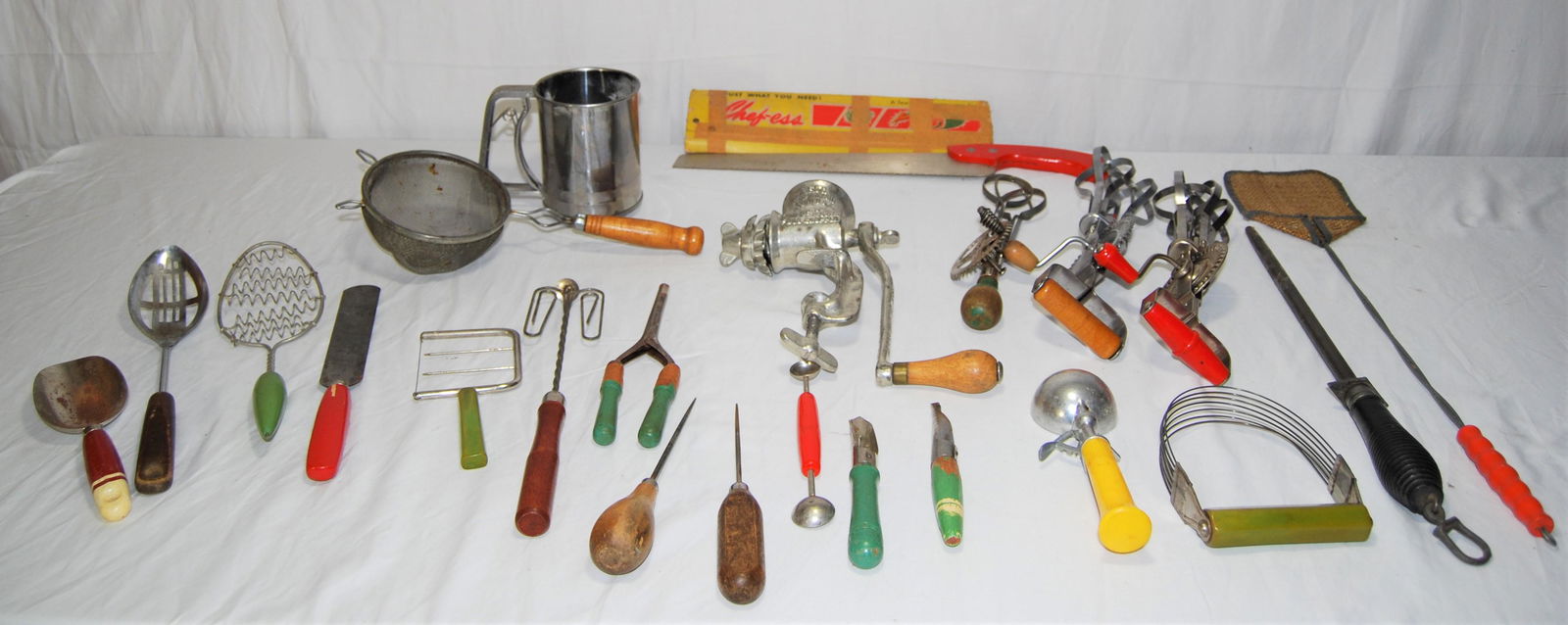 Vintage Kitchen Tools-many wood handled-23 items: Vintage Kitchen Tools, many Wood Handled. Lot of 23 items includes: 1949 “Chef-ess” meat saw with red handle, flour sifter, meat grinder, knife sharpener, hand mixers, ice cream scoop, pas