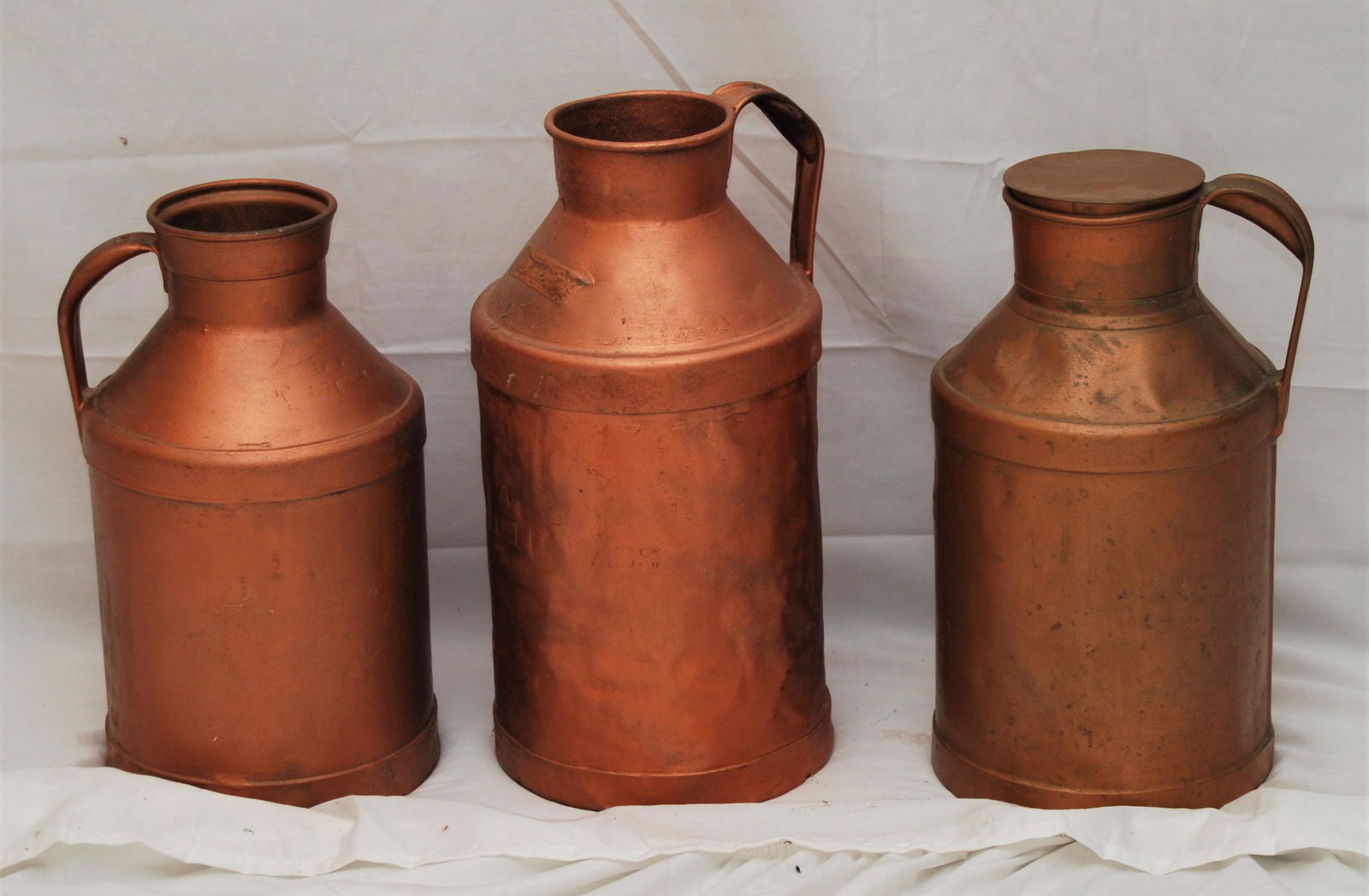 3 Vintage New England Milk or Cream Cans: Vintage New England Milk or Cream Cans. Lot of 3 items includes: One copper-colored can has some green aging patina, and is unmarked, 14½”h. The 2 other cans are painted in a copper color.