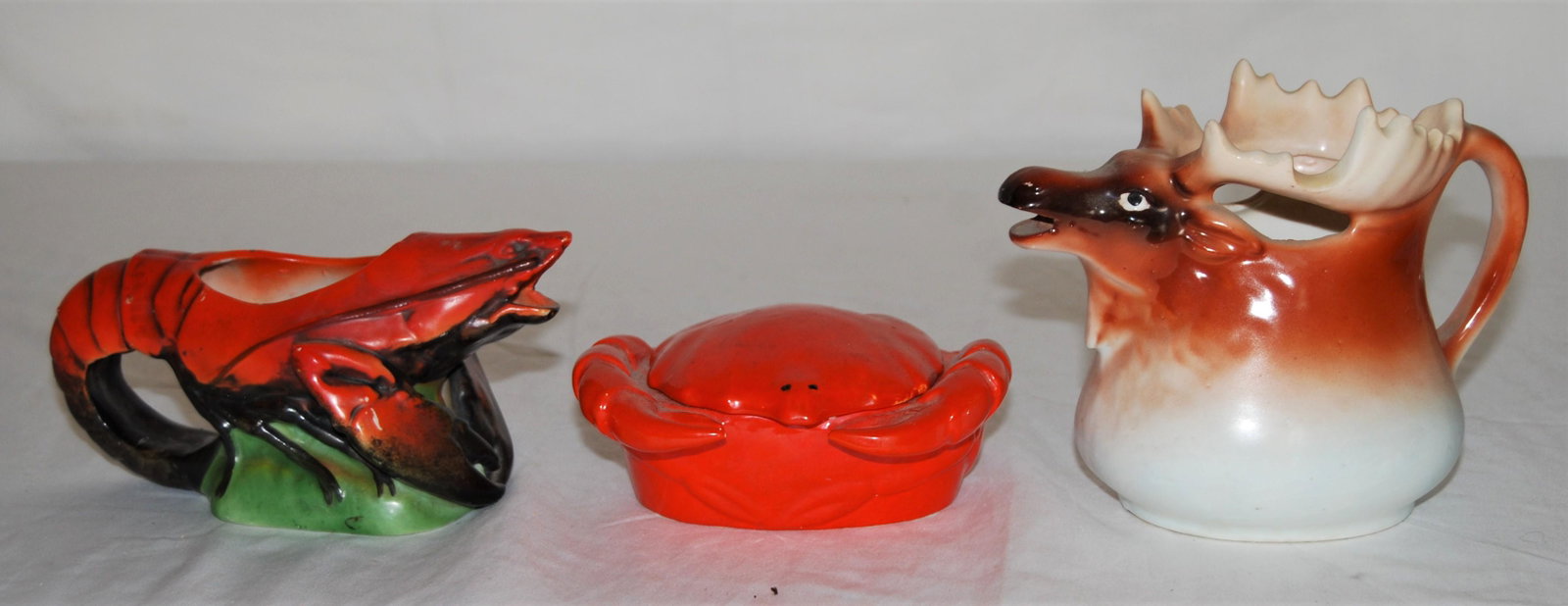 Surf & Turf-Lobster-Crab-Elk Sugar & Creamers: Surf and Turf Pottery, Lobster, Crab & Elk Sugar & Creamers. Lot of 3 items including: a lobster creamer, 6 ½”w, a crab sugar bowl with top, 5”w, and an elk creamer, 4 ½”h,