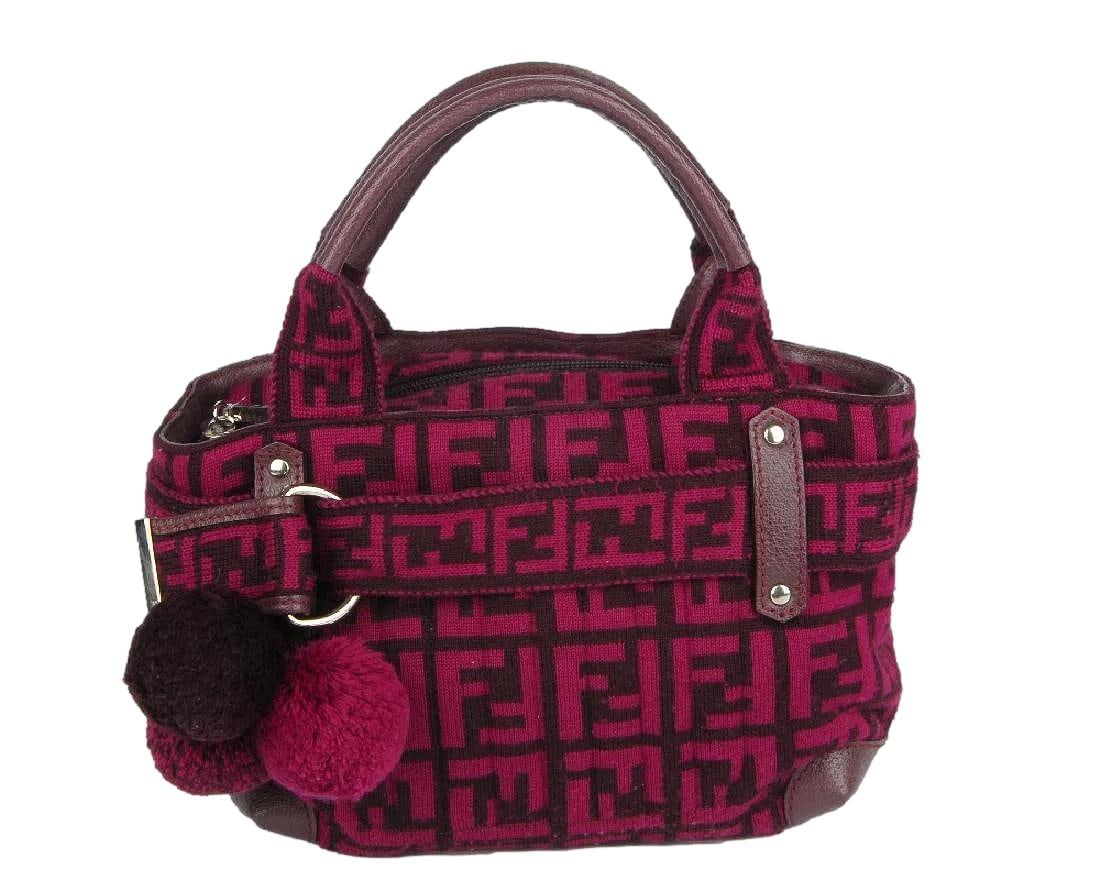 Fendi Zucca Pink and Purple Knitted Handbag.: 10 x 7. This knited bag is so adorable. It has a small exterior front pocket and is lined with a pink satin interior. It appears to be unused. It has burgandy leather trim and 3 pom poms in the front.