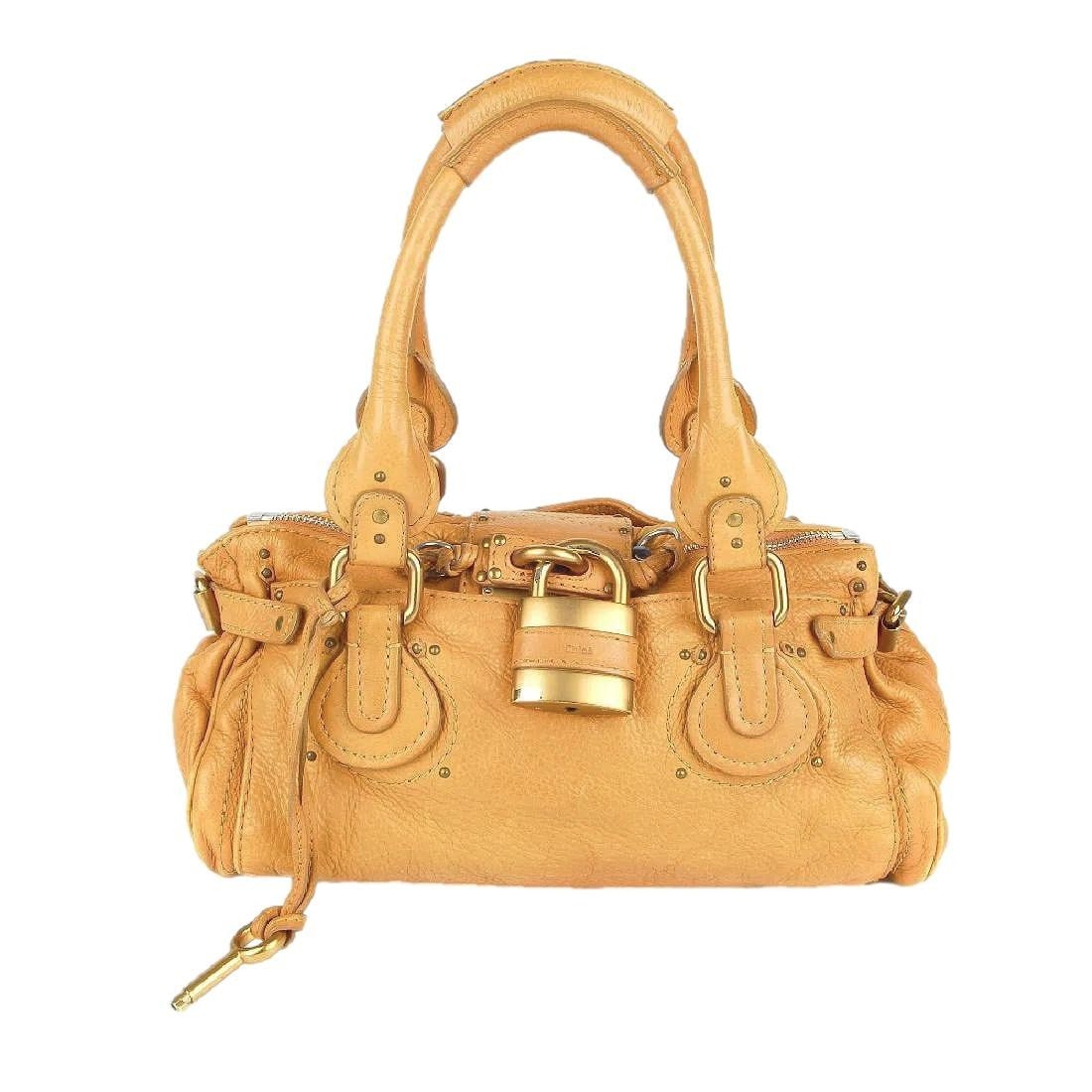 Tan Calfskin Leather Paddington Handbag by CHLOE'. Features Trademark Front Lock with Key. Brushed: Previously Owned. This bag shows some use. Any annomolies are provided in the pictures.