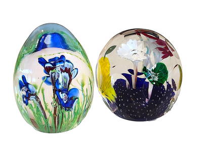 2 Vintage Glass Paperweights Featuring Flowers: One appears to be Iris Flowers and the other has mutiple colored flowers in a Navy Blue Base. 2 1/2" and 2 3/4".