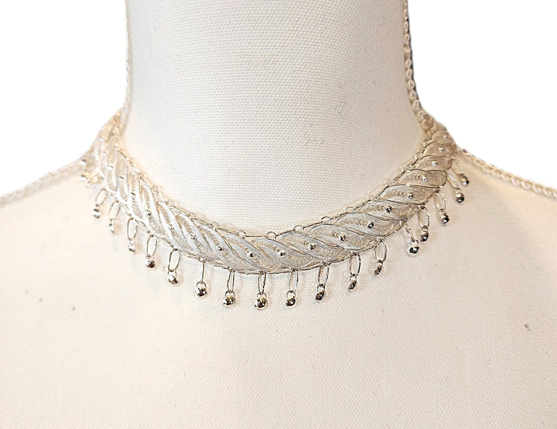 Sterling Silver Necklace with Drop Features - New: This is from our collection of Sterling Silver Jewelry purchased from a store close out. This necklace features a fillagree feather motif with drop features. This is a choker size necklace. 14 1/2" le
