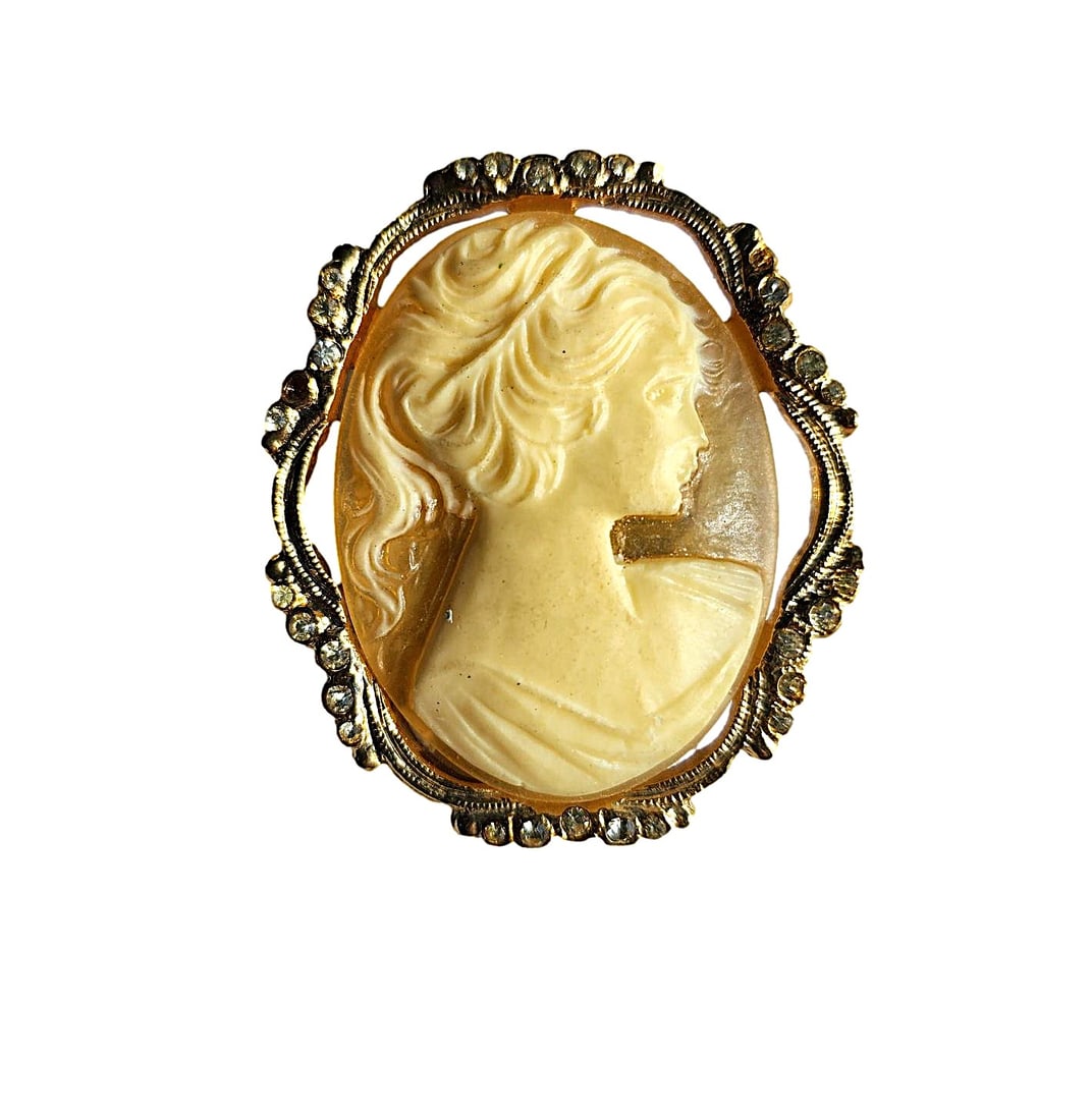 Very nice Vintage Gold tone metal Cameo Brooch - 1 7/8": This brooch is very nice with the figure set on a yellow lucite/acrylic type background. Crystals line the outside of the Brooch. 2 crystals are missing. The brooch measures: 1 7/8". The brooch has a