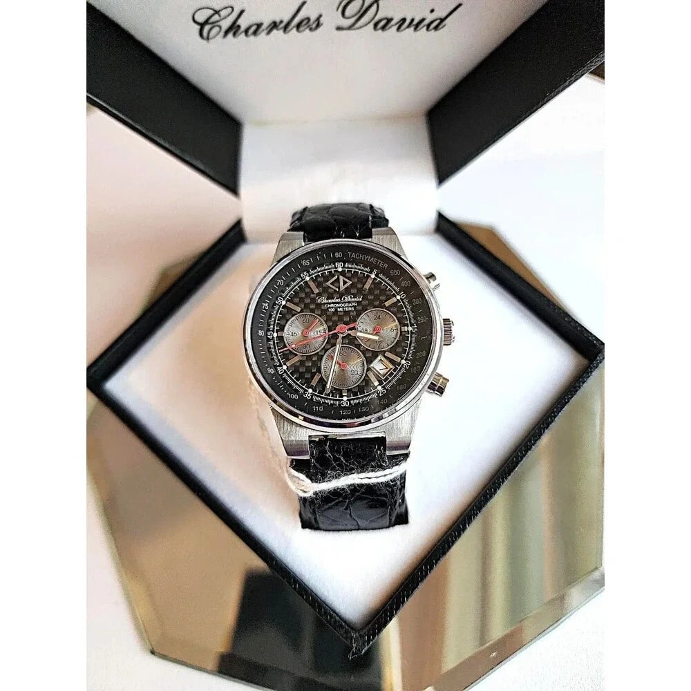Vintage Charles David Men's Magma SS Wristwatch w/ Embossed Leather Strap. 31713: Water resistant to 100 Meter. Sapphire Chronographic 1/1 sec Basis. Stainless Steel Case. Carbon fiber watch face. We have a collection of Men's watches we bought from a store closure sale. These are 