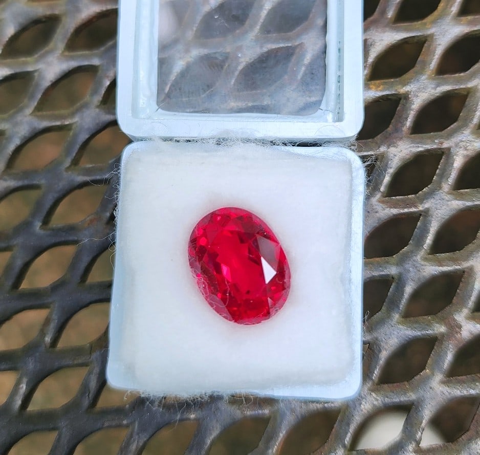 Beautiful 10.7ctw Red Sapphire - Oval Cut - Look at this color!: This gemstone is one of mine. It was sold to me as a Red Topaz, but our in-house testing shows it to be a Sapphire. The pictures do not capture the deep and vibrant red color. The pictures pick up a p