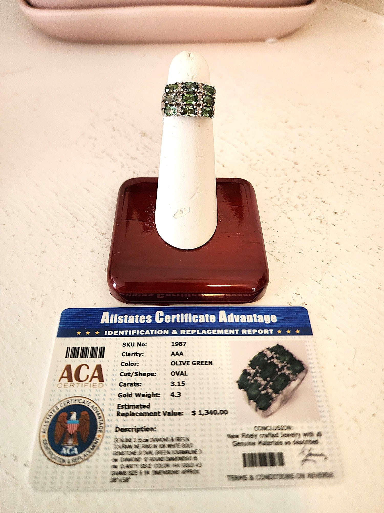 Diamond and Green Tourmaline Gemstone Ring in 10K White Gold Setting: Very nice 3 layer Olive Green Tourmaline - 9 Oval cut gemstones with 12 Diamond Chips. Clarity: AAA. Carat weight - 3.15. Size: 6. This ring comes with a certification card. Value: $1340.00