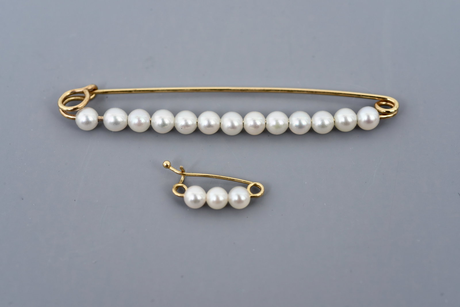 Pair of 14k Yellow Gold Pearl Pins: Weight: 2.5 grams (gross) Dimensions: - Longest pin measures 2 1/4" long - Shorter pin measures 5/8" long Longest pin only is marked Tiff & Co./14K Town Auction House & Gallery offers local delivery t
