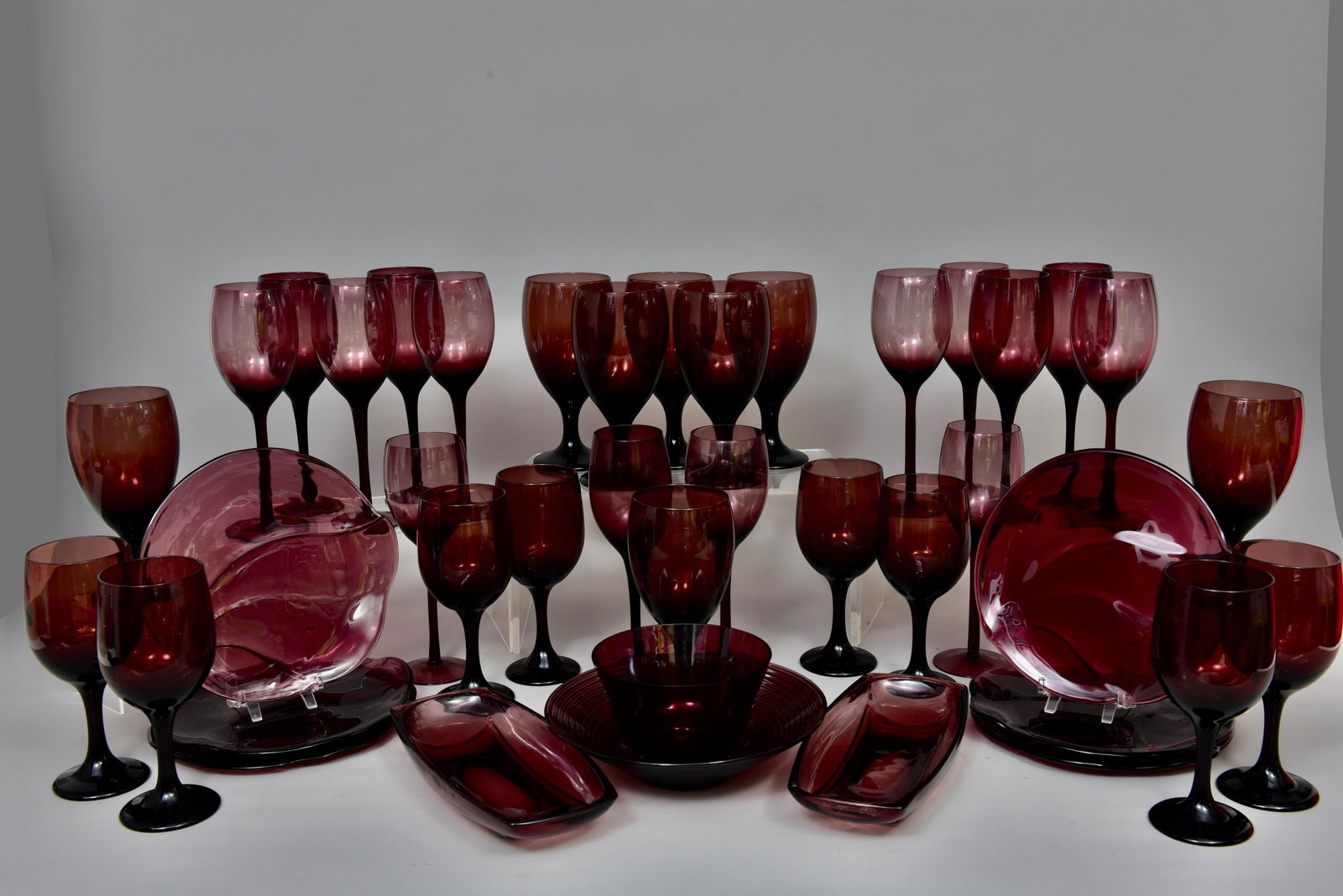 Collection of Amethyst Glasses and Bowls: Including: - Set of 8 goblets: 7"H - Set of 6 Mulberry plates: 8 1/4”Diam. - Set of 8 Libbey Amethyst wine glasses: 7”H - Set of 14 Libbey long stem wine glasses: 8 1/2”H - Two oblon