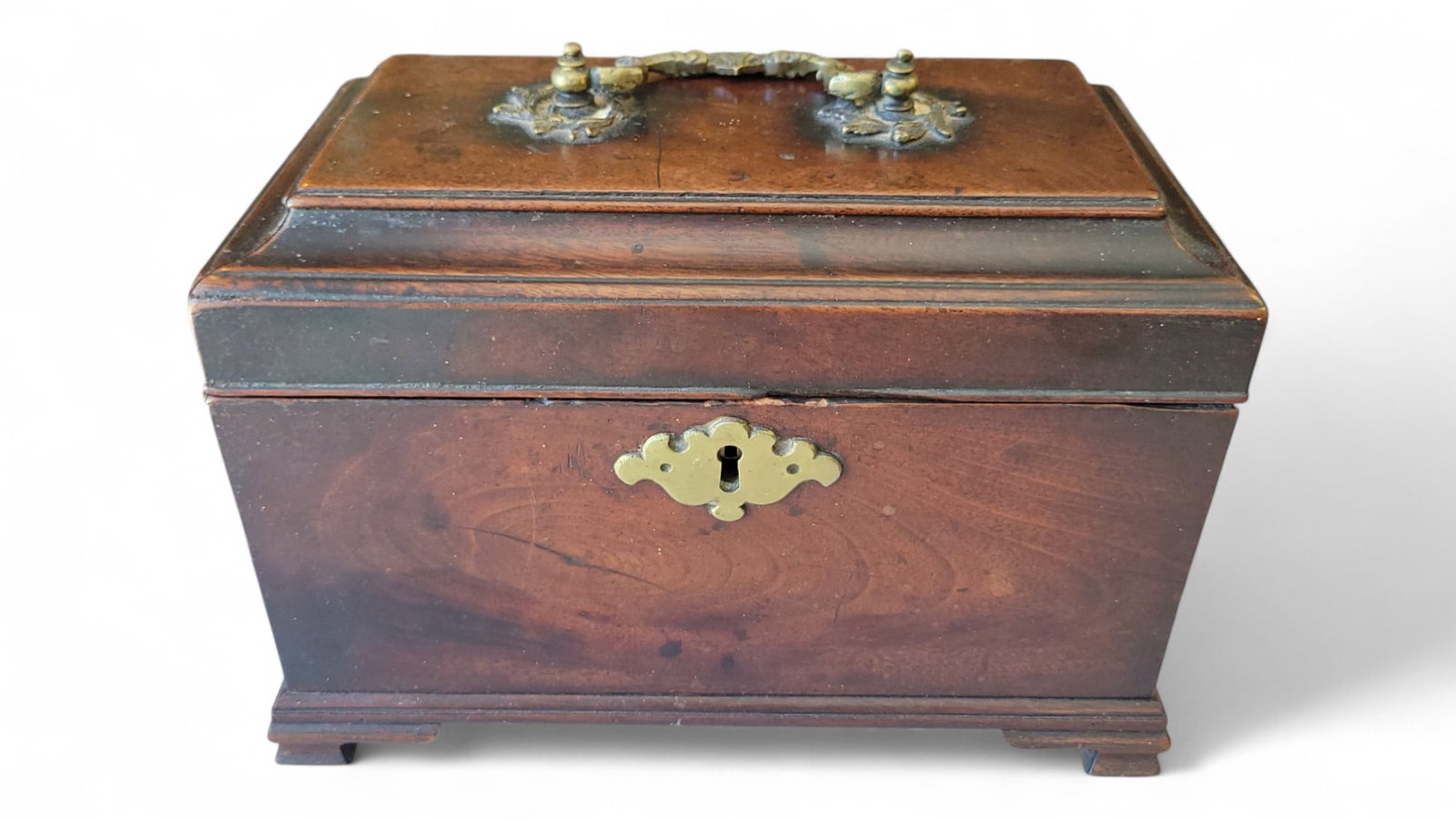 Georgian Mahogany Tea Caddy: Georgian mahogany tea caddy. Sitting on bracket feet with original brass handle. The interior has 3 individual cavities. Width 9.5" Height 6.5"