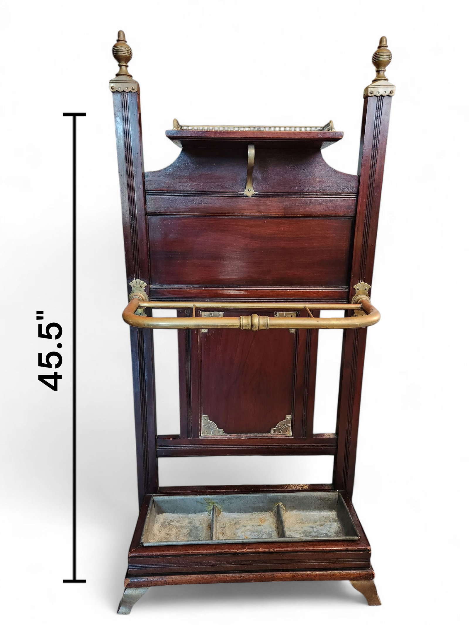 Stick Stand, attributed to James Shoolbred & Co: Oak and brass mounted stick stand attributed to James Shoolbred and Co. Having raised three-quarter pierced gallery above a paneled back with turned brass finials and stick/umbrella holder to a mounte