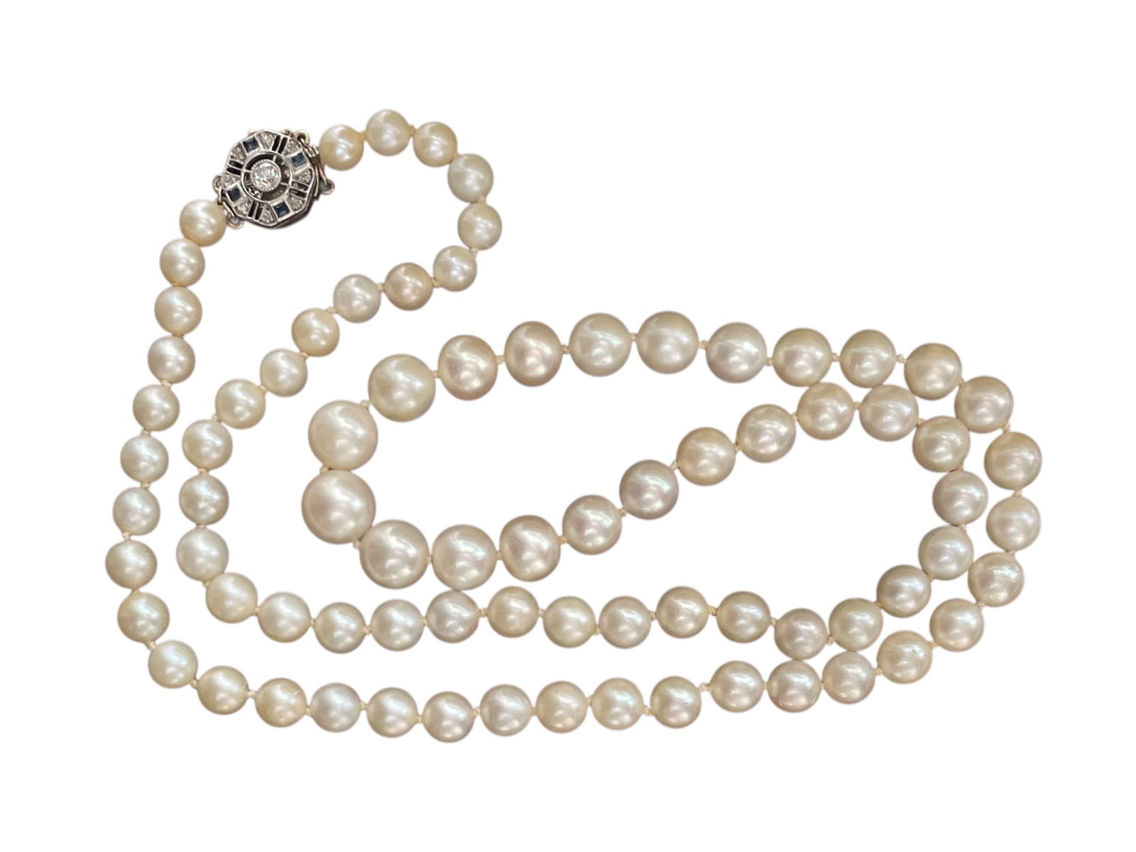 Graduated Pearl Necklace with 14K Diamond Art Deco Clasp: Pearl Necklace with 14K Diamond Art Deco Clasp A 24" strand of genuine pearls with an exceptional white gold clasp featuring several genuine diamonds and blue sapphire(?) accents. Marked 14K.