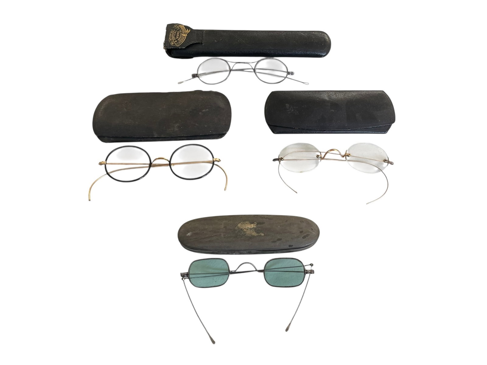 4 Pairs of Spectacles with Cases: 4 Pairs of Spectacles with Cases. One pair of glasses has small green lenses. Two pairs are a little larger and look nice; they are probably gold filled. One of them has black rims and is stamped