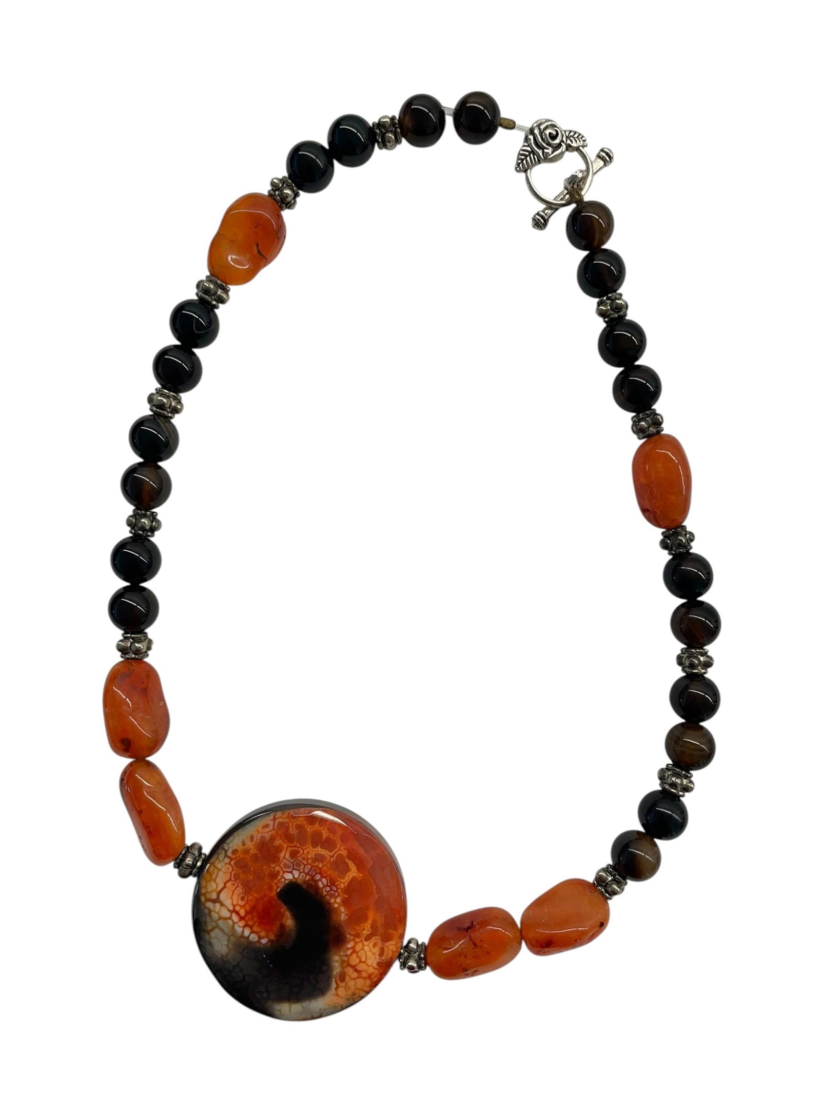 Black Onyx and Carnelian Beaded Necklace: Black Onyx and Carnelian Beaded Necklace. New handmade necklace with a nice rose toggle clasp. Featuring a faceted center stone, and black and orange polished beads. 18" length.