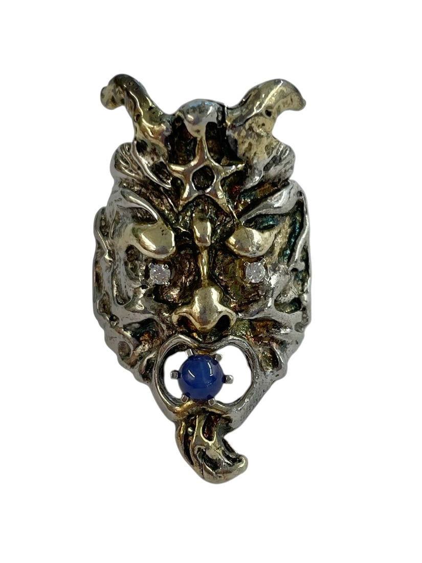 Gargoyle or Demon Ring, Sterling Silver with Star Sapphire: A vintage biker's ring featuring a blue star sapphire in the figure's mouth, crystal eyes, and gold accents on the features. It's marked Sterling. Size 8 1/2.