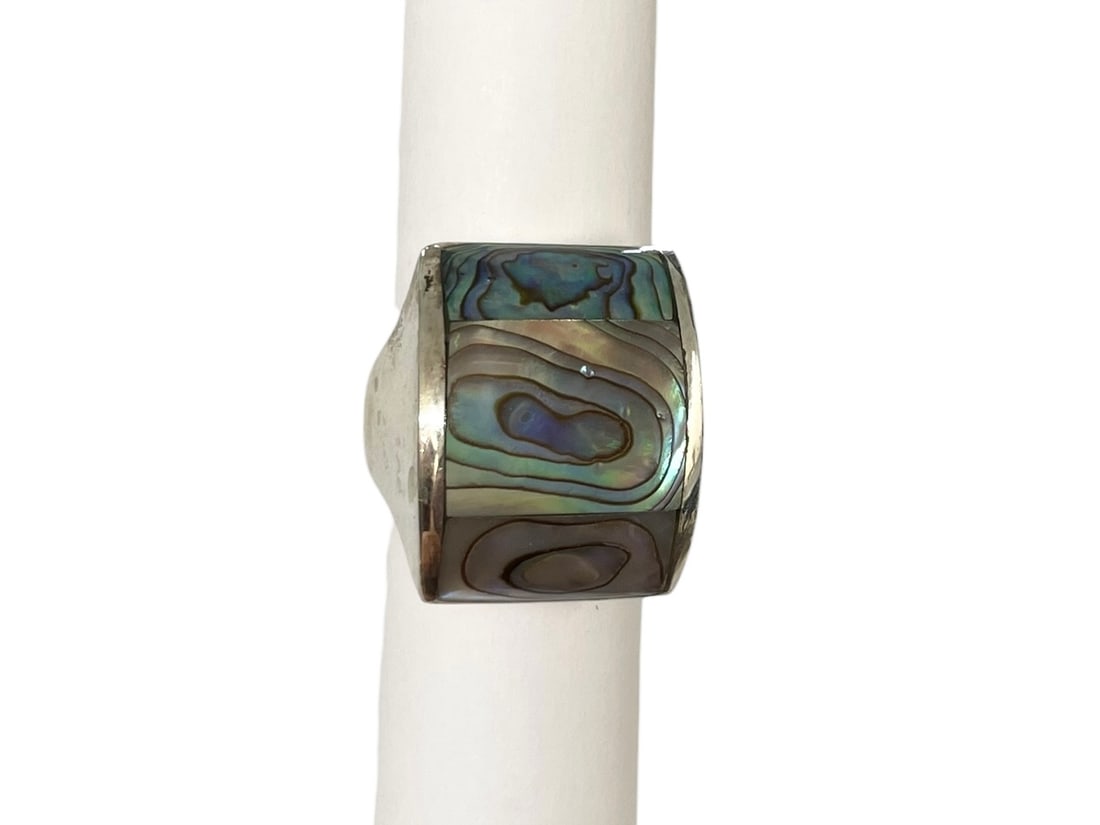 Abalone Sterling Silver Ring: Size 7. Marked: 925. Fairly large unisex ring with opalescent colors of abalone shell. Weight: 12.1 grams