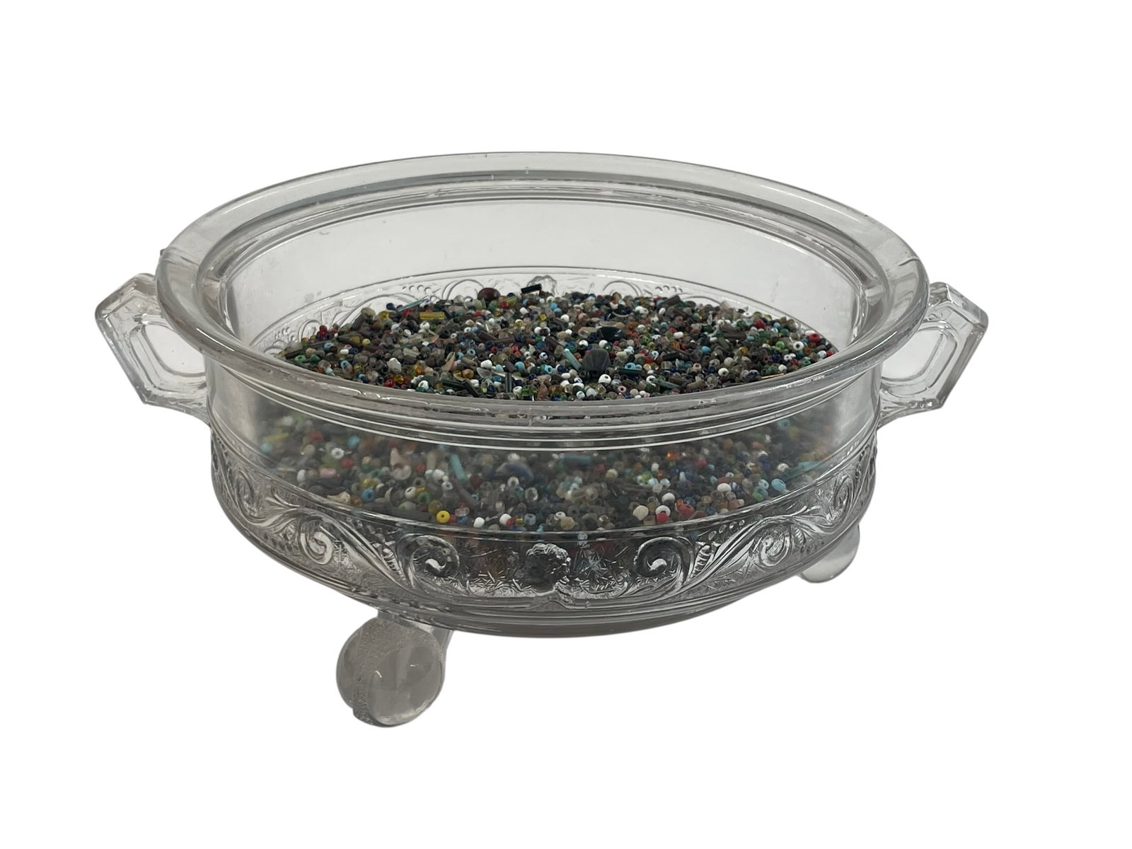 Native American Seed Beads in a Glass Bowl: 19th century tiny glass beads, collected in an antique glass bowl. The double-handled bowl is three-footed and is about 8" diameter. Interesting item!