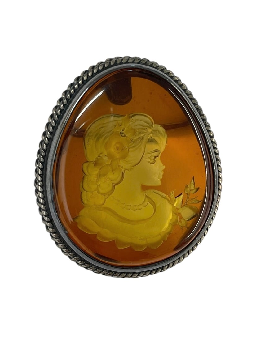 Reverse Carved Amber Cameo Brooch, Sterling Silver: Baltic Amber intaglio carved with a portrait of a lovely lady. Set in sterling silver, marked 925. Length: 1 3/8" Weight: 15.4 grams