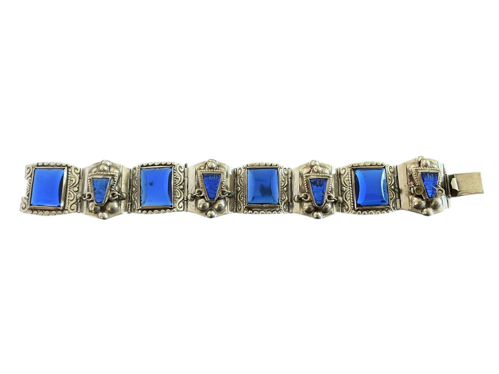 Mexican Silver and Blue Glass Bracelet ~ 43 grams: Blue glass, some carved with Mayan/Incan face motifs. Silver, marked with an eagle head, and "Hecho in Mexico". There are dangling beads alongside the faces and one is missing (not hig