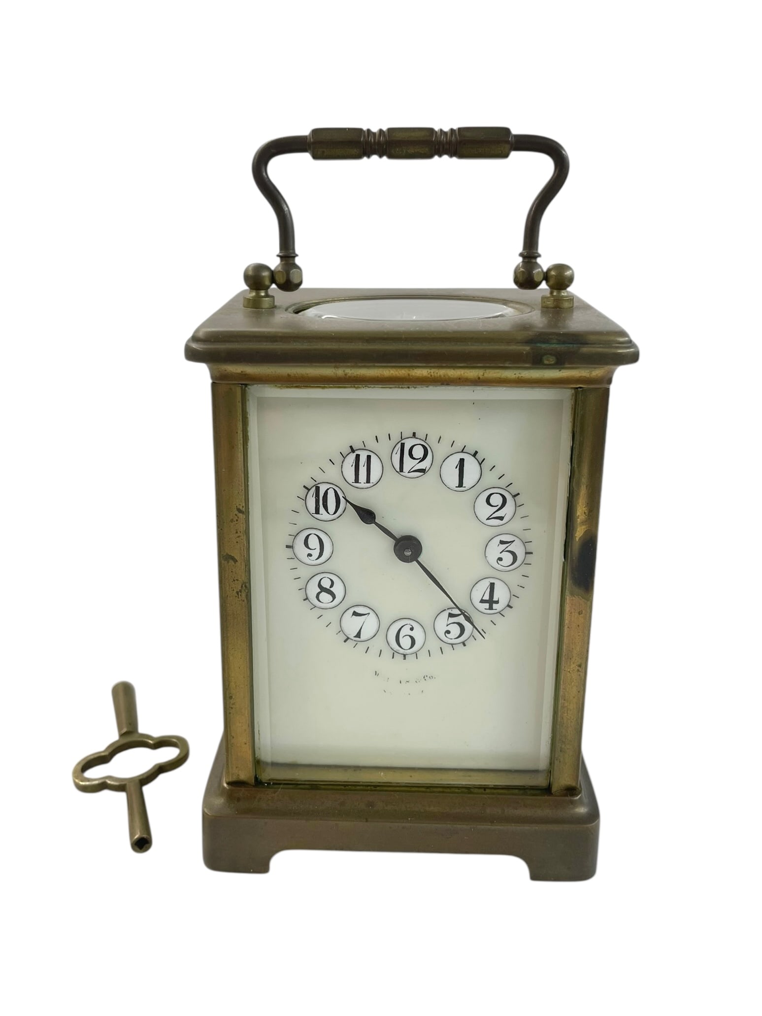 French Brass Carriage Clock with Key: The maker's name is on the face but mostly rubbed off. Key included. 5 3/4" tall including raised handle.