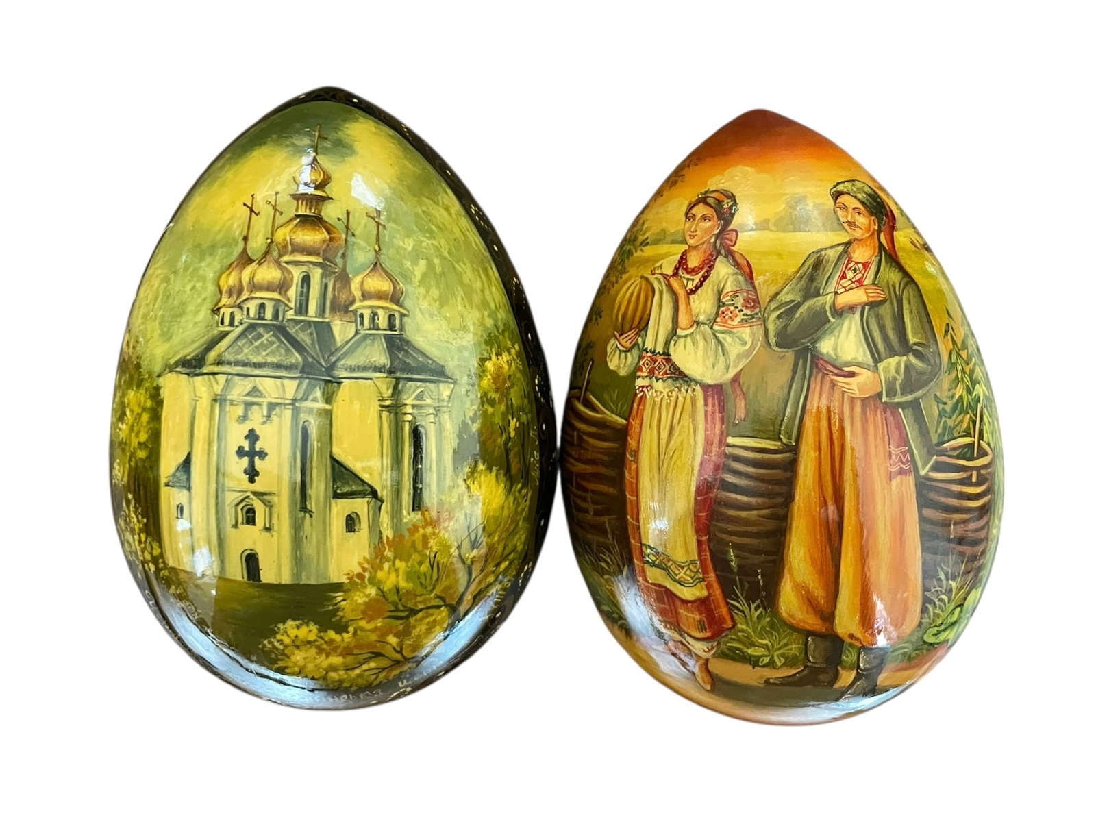 2 Hand Painted Russian Eggs: Original art on wood, each is signed as pictured. Both pieces are highly detailed: a couple near a countryside home, and a church with embellished cross design. 4.5" tall each, not small.
