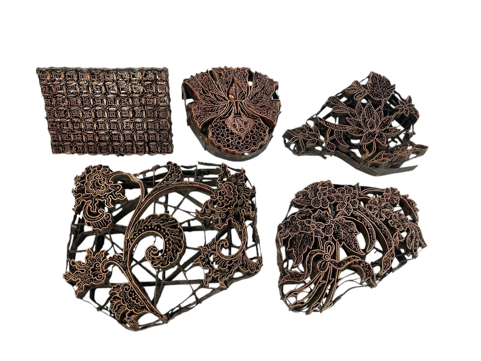 5 Indonesian Copper Stamps for Batik Fabric: A collection of 5 antique handmade metal stamps, mostly floral design, one with a repeating pattern (the only one with a handle). The metal is showing age and use. The copper patterns are