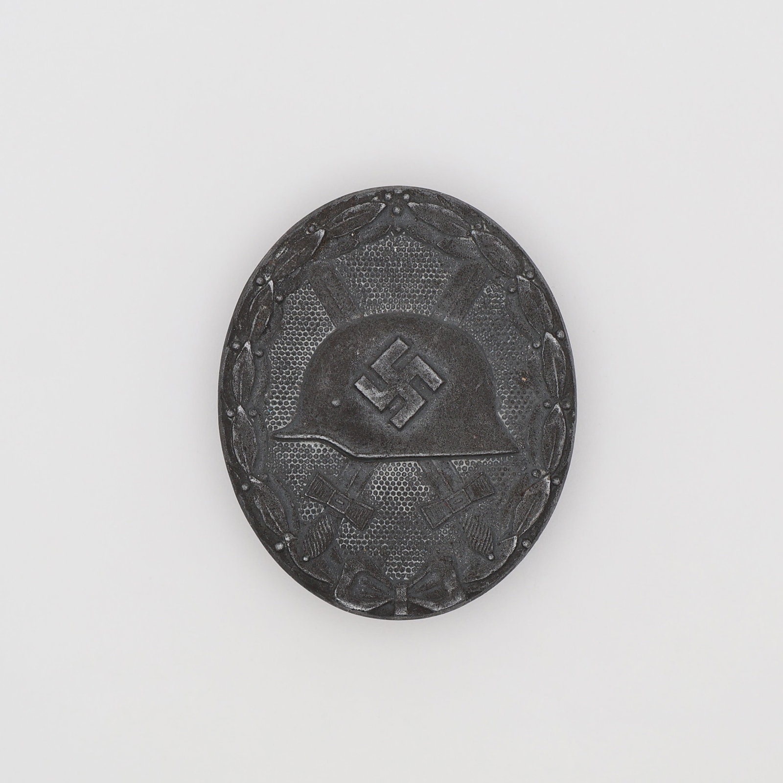 German WWII Silver Wound Badge: German, Third Reich (c. 1939-1945). Wound Badge (Verwundetenabzeichen), Silver Grade, 1939 type, in silvered tombac, the oval face with an M1935 steel helmet bearing a mobile swastika over crossed swo