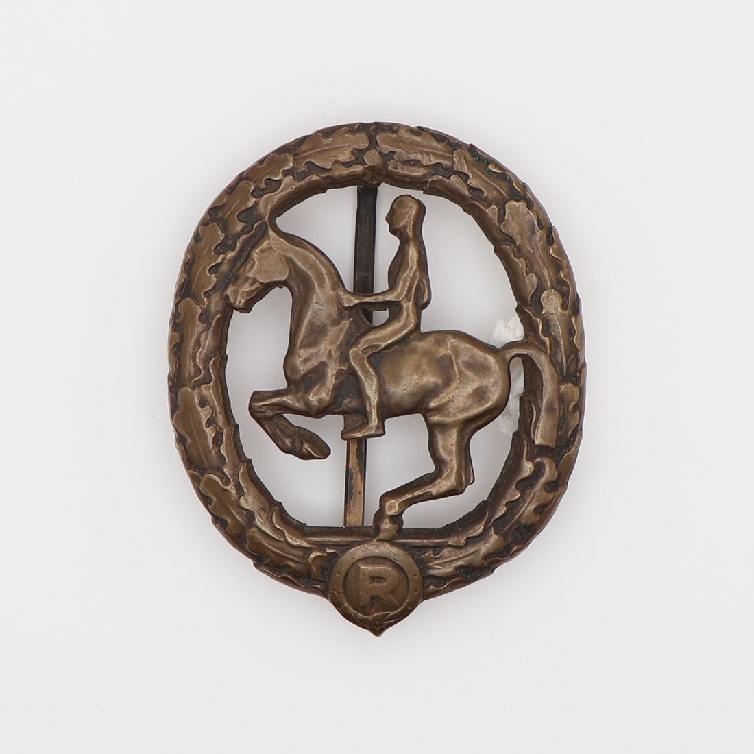 German WWII Horseman's Badge in Bronze: German, Third Reich. German Horseman's Badge (Deutsches Pferdesport-Leistungsabzeichen) in bronze, oval, the obverse with an oak wreath enclosing a mounted rider above a horseshoe and the letter 'R', 