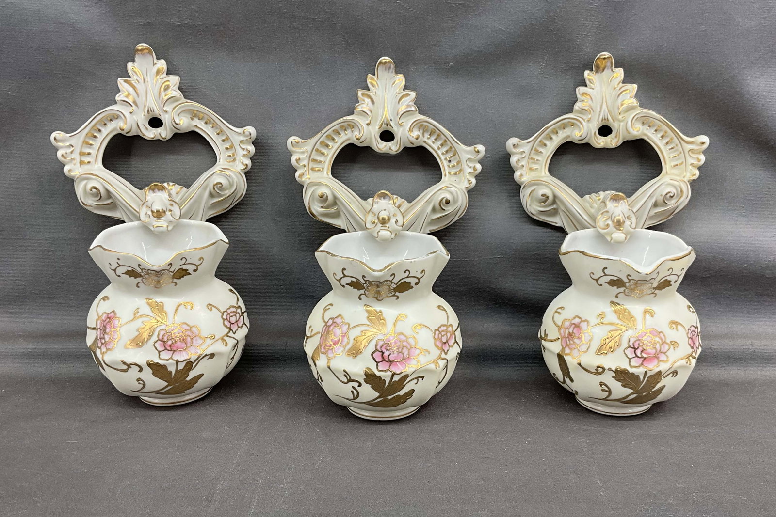 Group of 3 wall pockets from Kalk Germany. Floral motif with gold painted accents. Some paint: Group of 3 wall pockets from Kalk Germany. Floral motif with gold painted accents. Some paint losses. Marked on underside. Size: 8.5"T x 5.25"W x 4.5"D