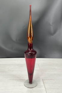 Modernist glass decanter from Blenko, stamped on  underside, red body with amber stopper. Size:: Modernist glass decanter from Blenko, stamped on underside, red body with amber stopper. Size: 21.25"T x 3.75" diameter