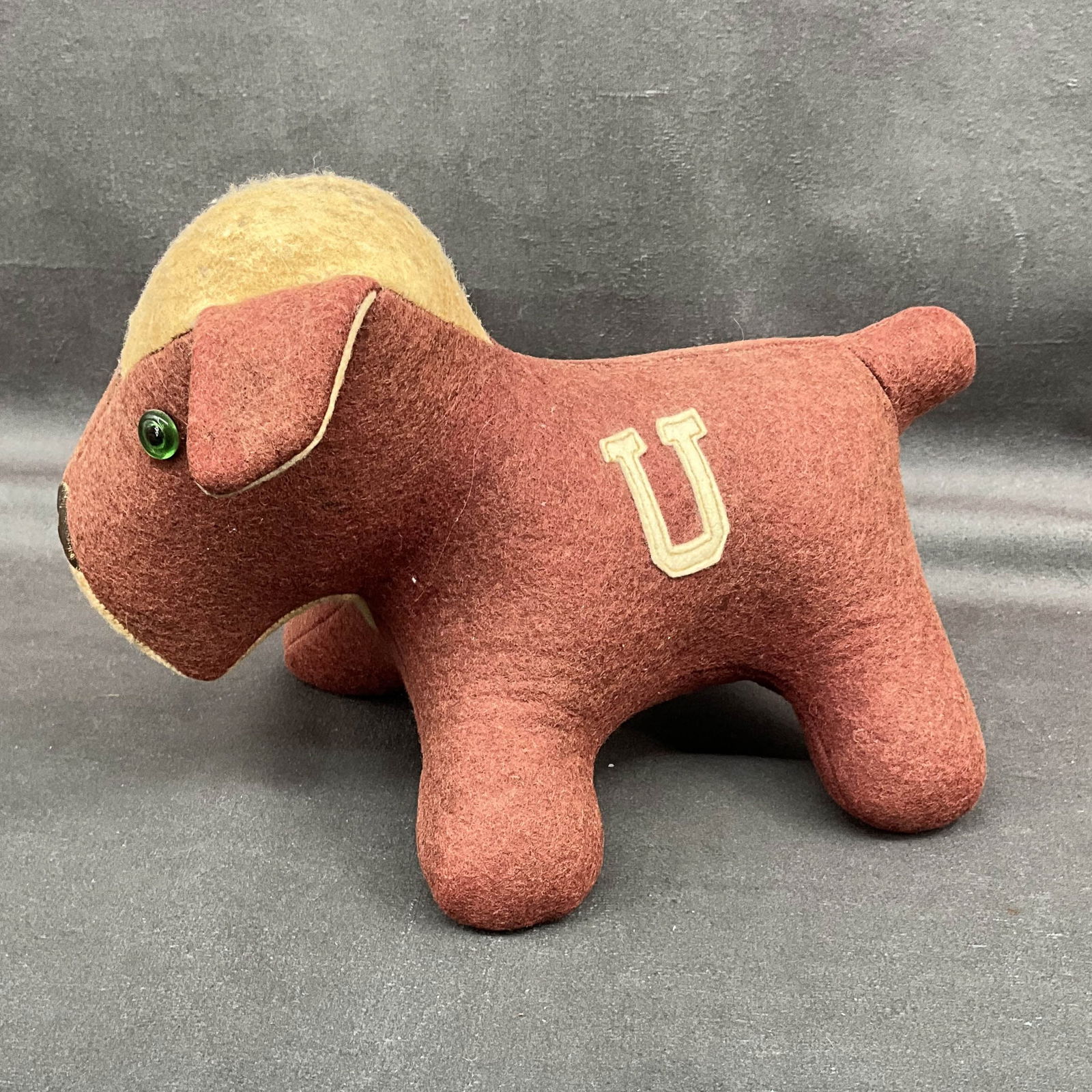 A College Pet, Collegiate MFG Co: An early stuffed Felt dog with hay filling. Labeled underneath as A College Pet, Collegiate MFG Co, Ames IA. Wear to top of head and strings at mouth. Size: 6:T x 5"W x 8"D