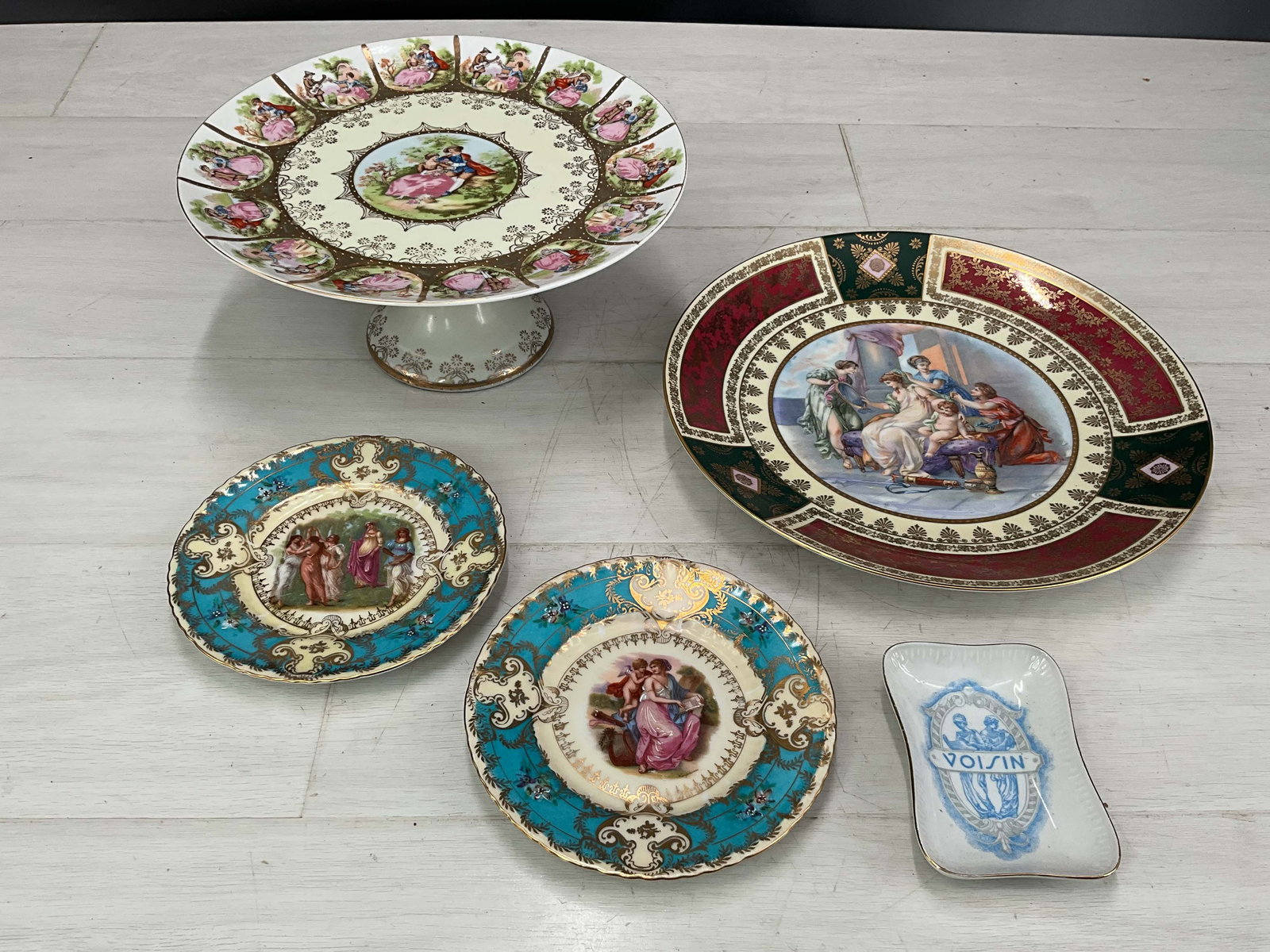 Bohemian Style Service Ware, 5 Pieces: Selection of dishes with figural imagery, cake stand, dinner plate, 2 side plates, trinket dish. Stamps on bottom as seen in photos, Germany & Austria. Size: largest: 5" tall x 10.5" Diameter