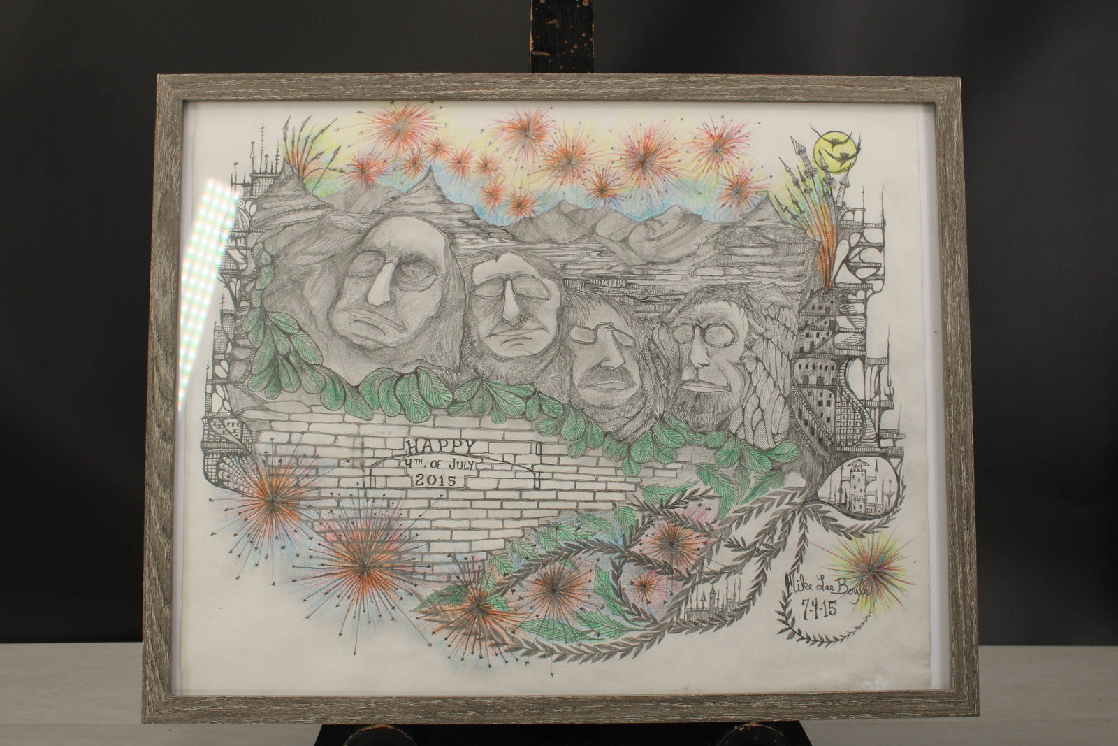 4th of July, Americana Outsider Art, Pano Style: Pano style, folk art depicting a stylized Mount Rushmore and architectural elements. Happy Forth Of July2015, framed, signed Mike Lee Boyle 7-4-15. Size: 14.75" H x 19" W